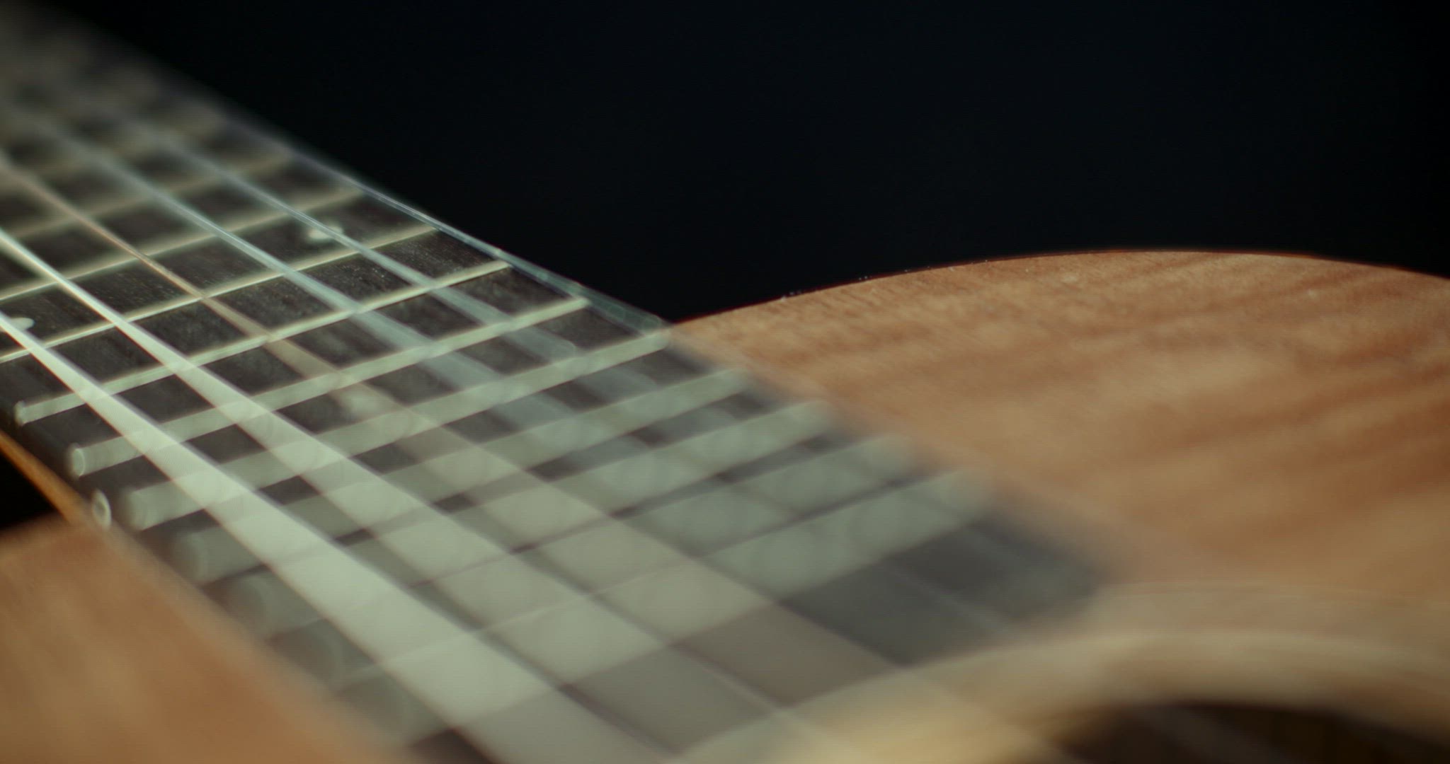 Slider shot over a guitar fretboard. Shallow depth of field.