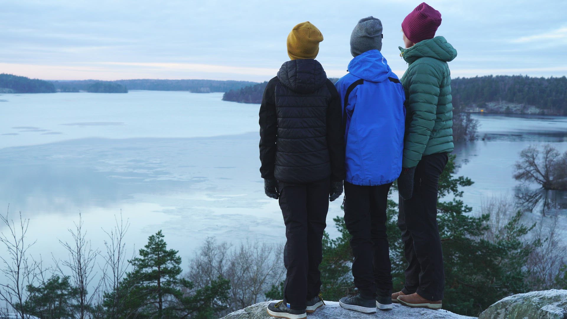 mother and two children standing at viewpoint looking out over lake Mälaren - wintertime