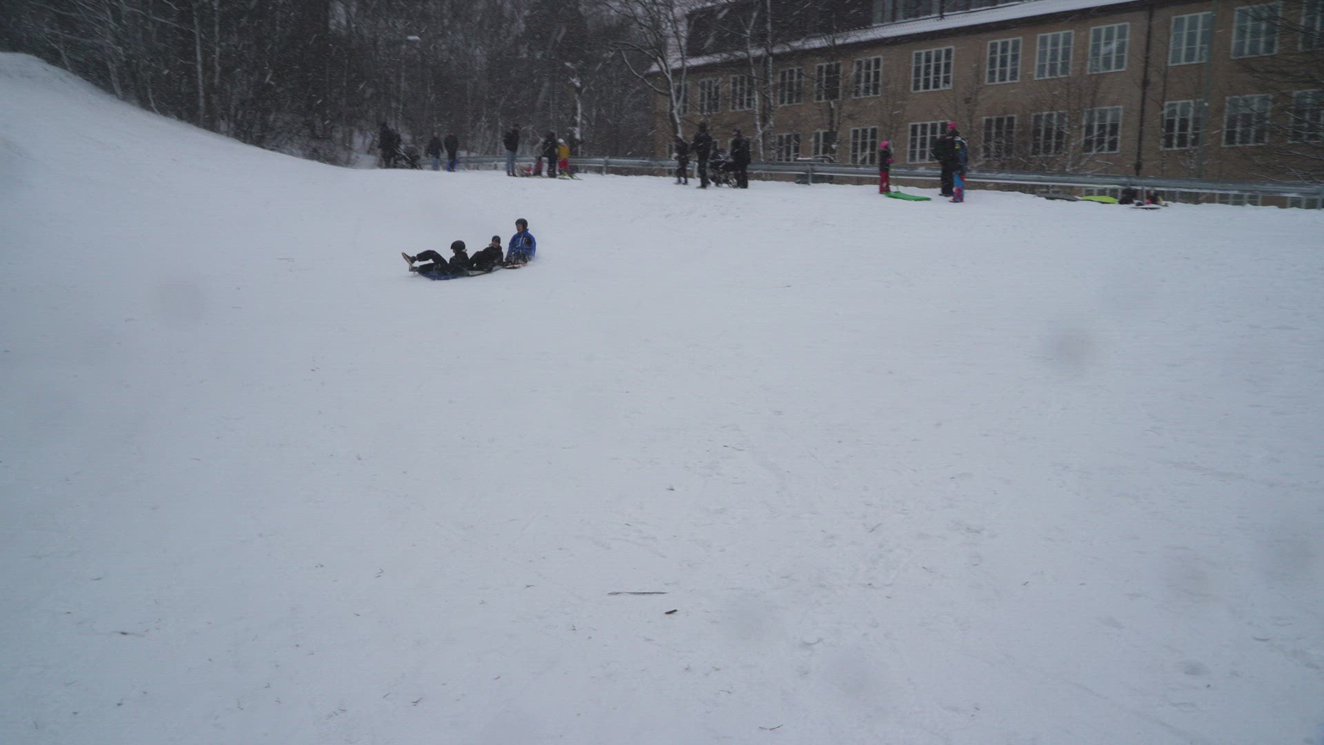 boys riding on snow gliders - hitting photographer that falls with camera