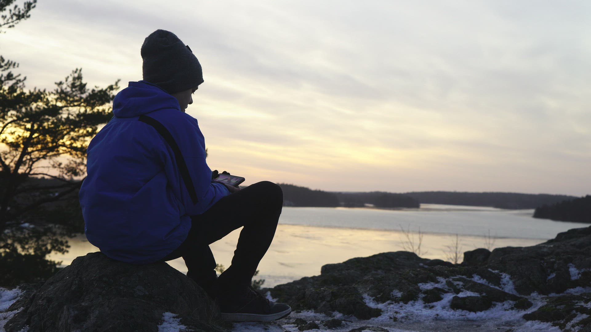 boy with cell phone at viewpoint - watching film om mobile phone