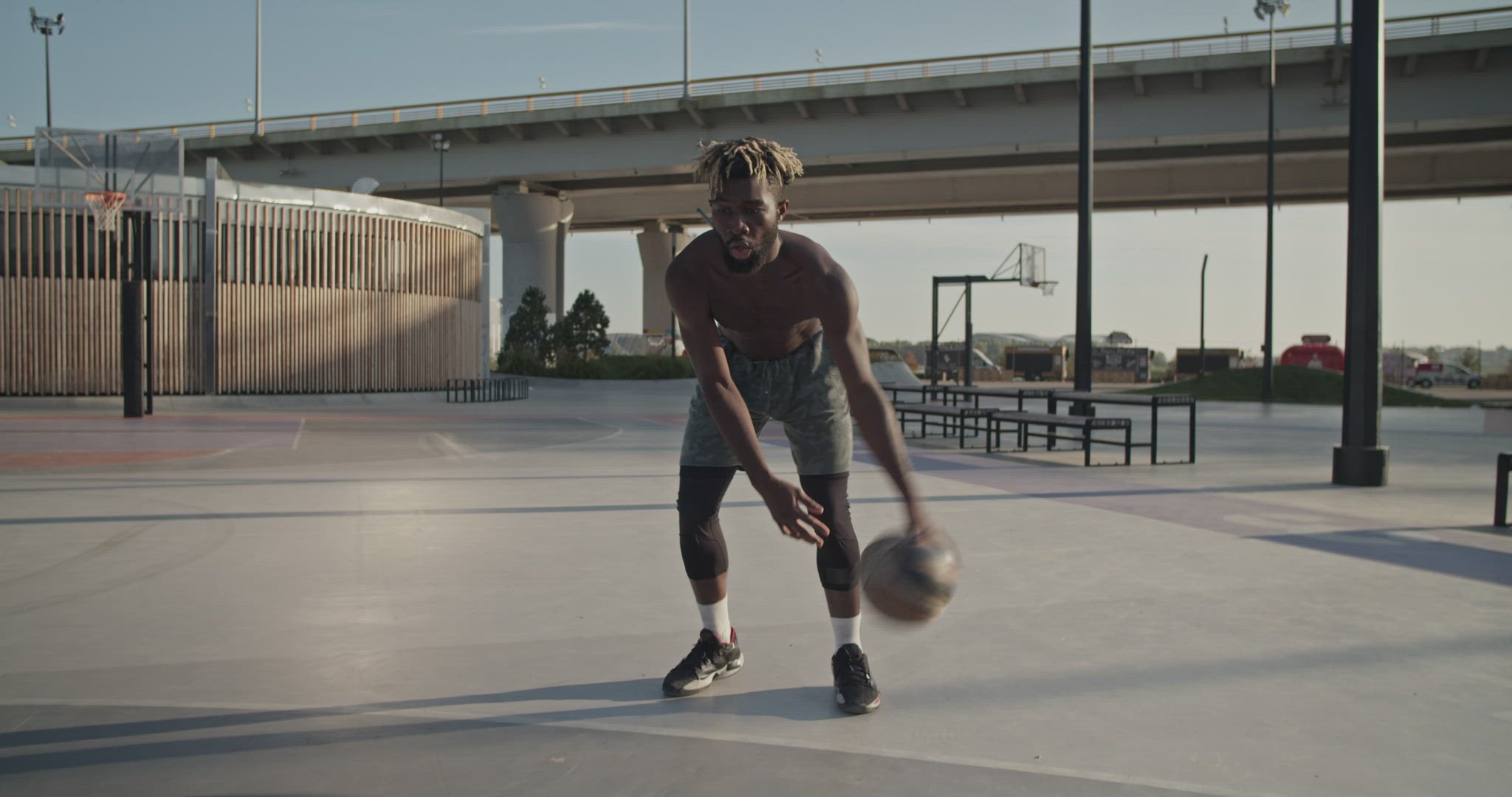 Black athlete doing tricks on streetball court