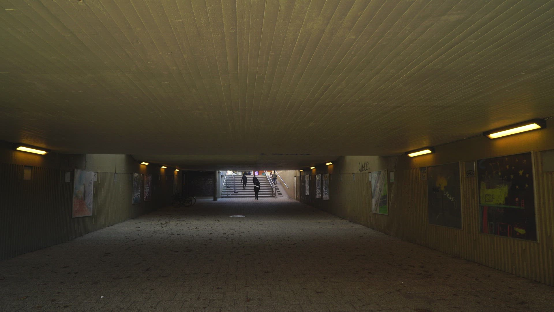 people walking through concrete underground tunnel in suburian area  - Stockholm