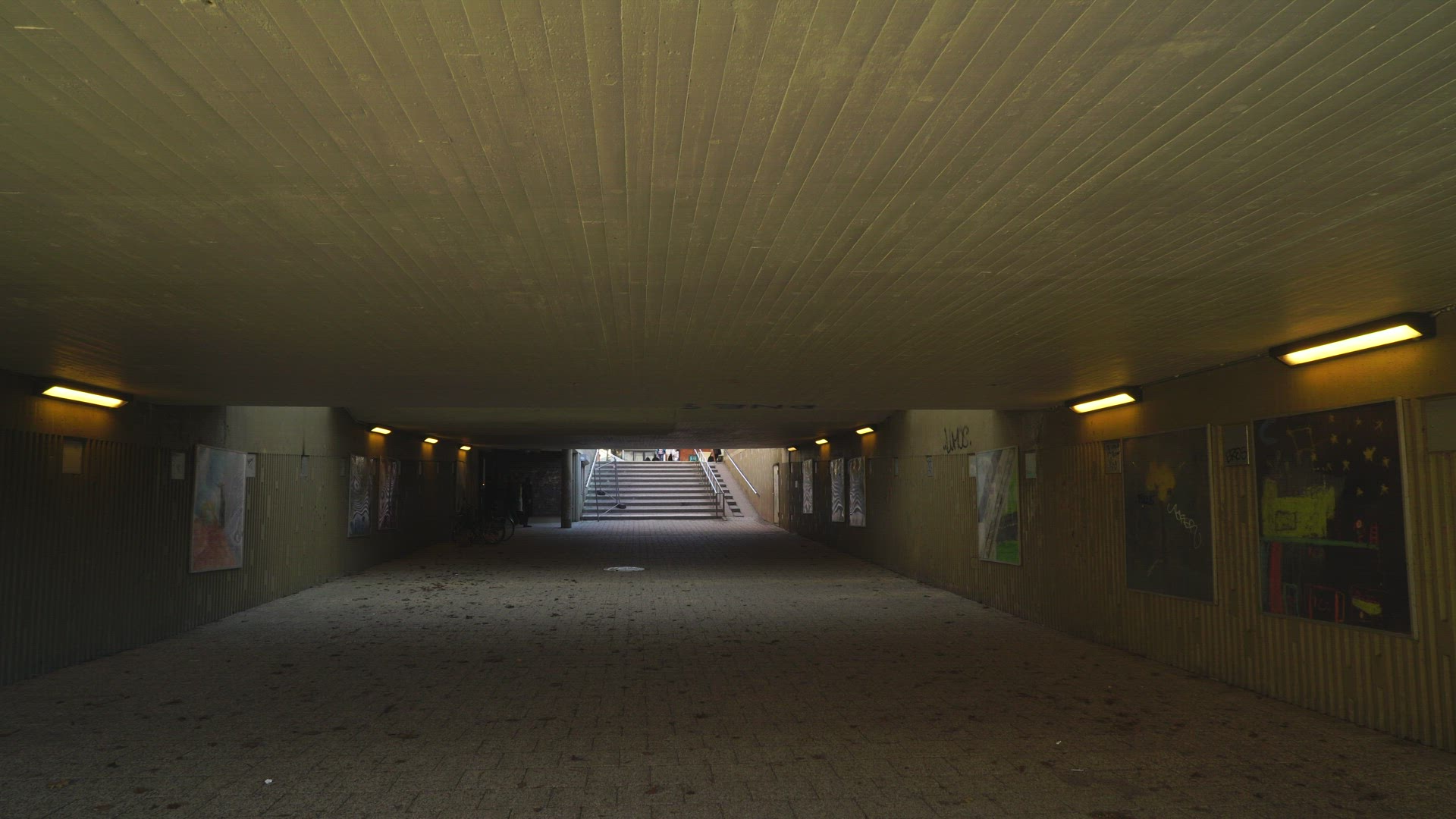 old woman walking through concrete underground tunnel in suburian area  - Stockholm