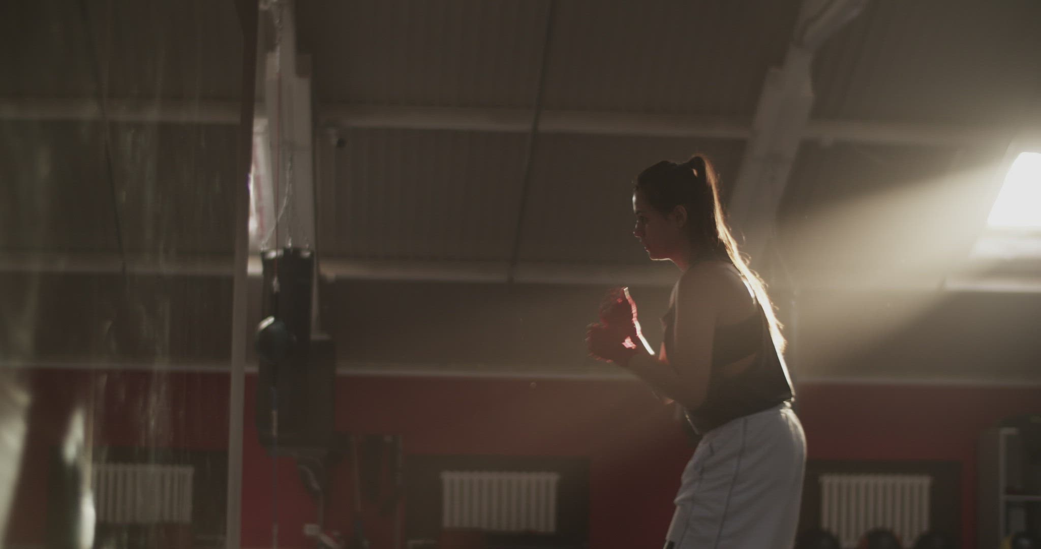 Sportswoman shadow boxing under sunlight