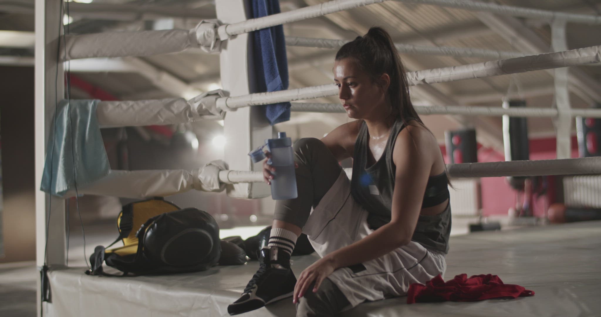 Tired female boxer drinking water