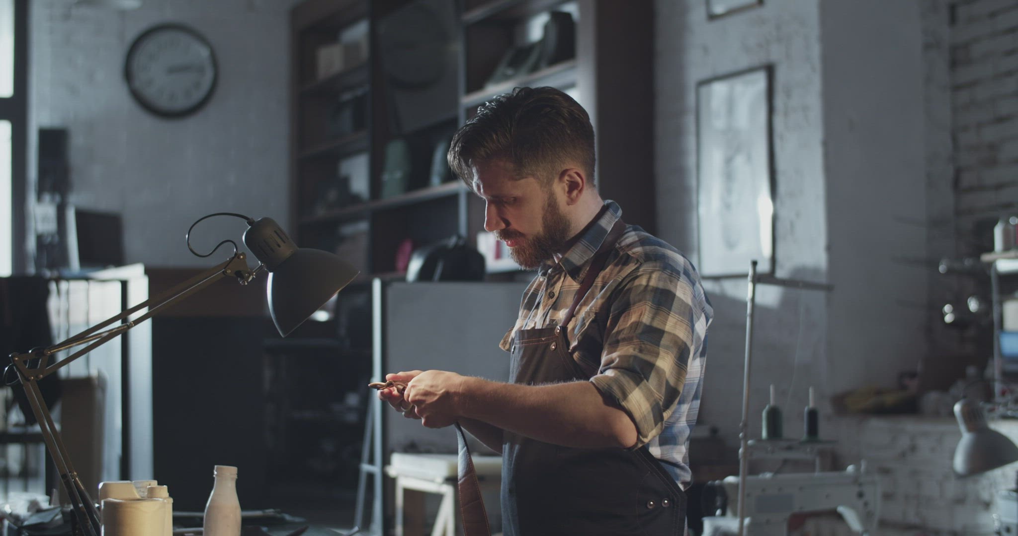 Male artisan examining leather belt