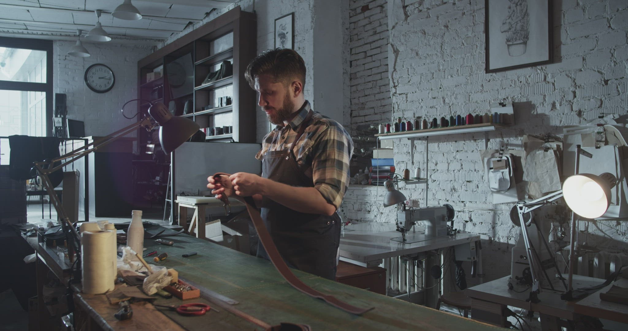Male artisan examining leather belt