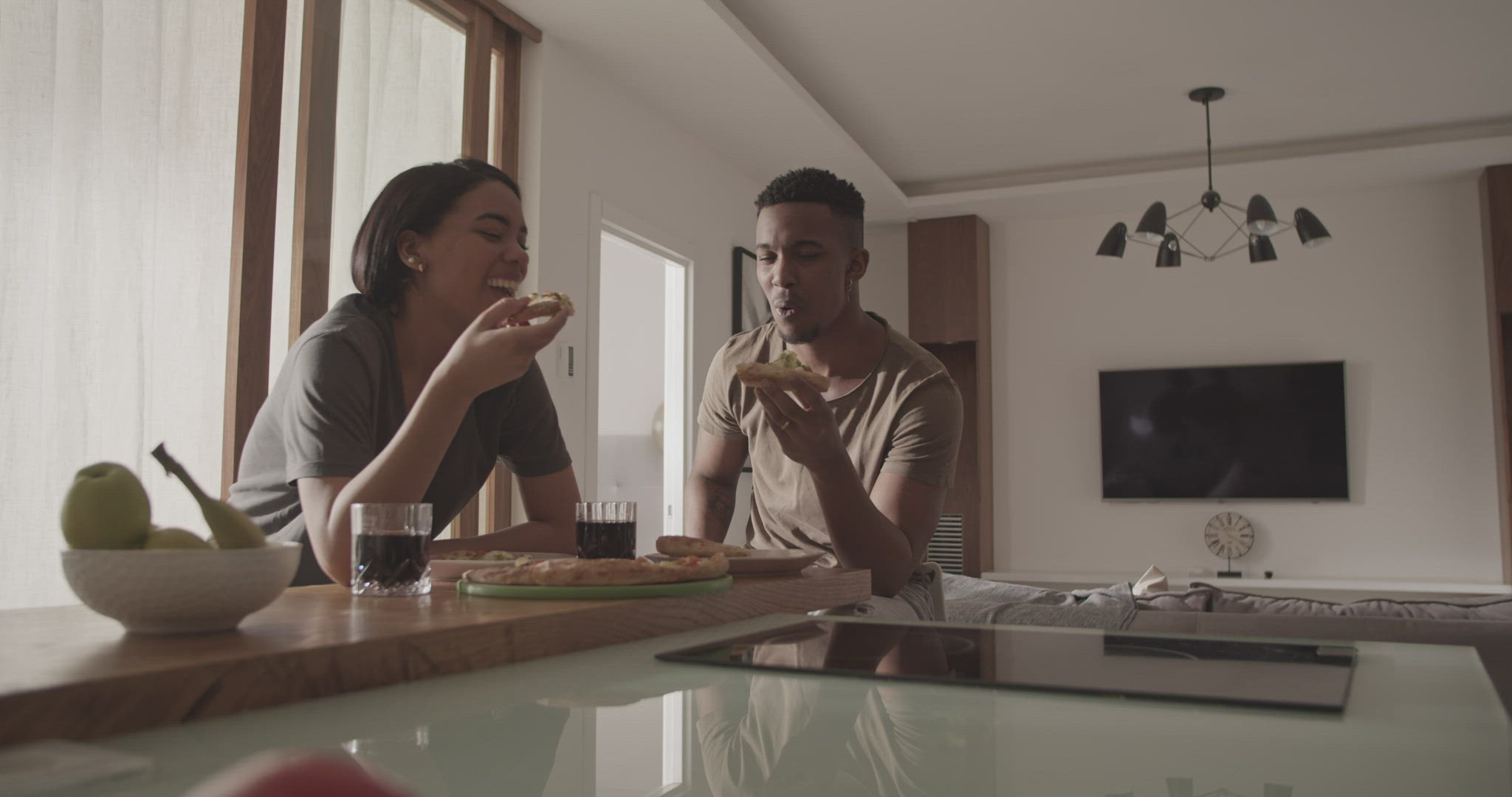 Multiracial couple eating pizza together