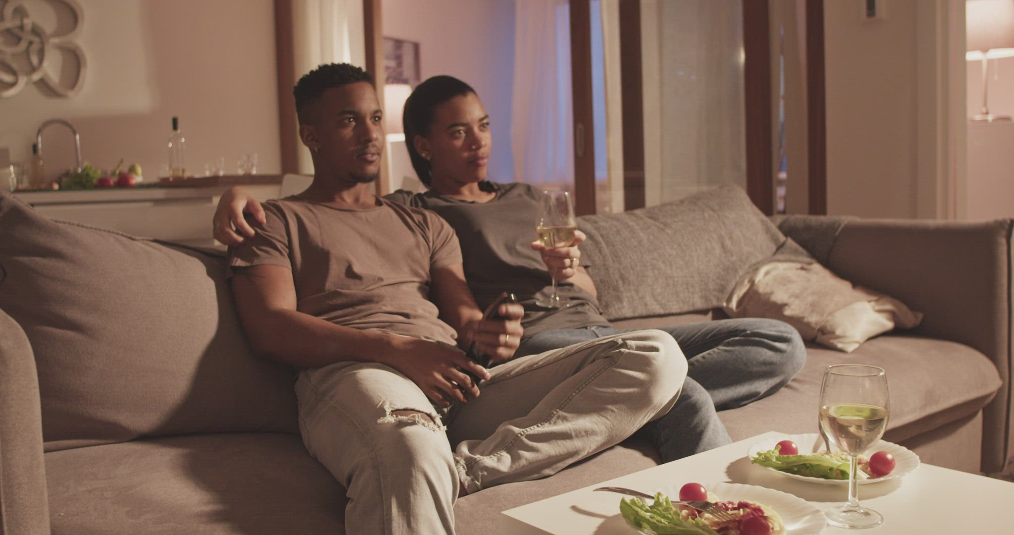 Diverse couple watching TV during date