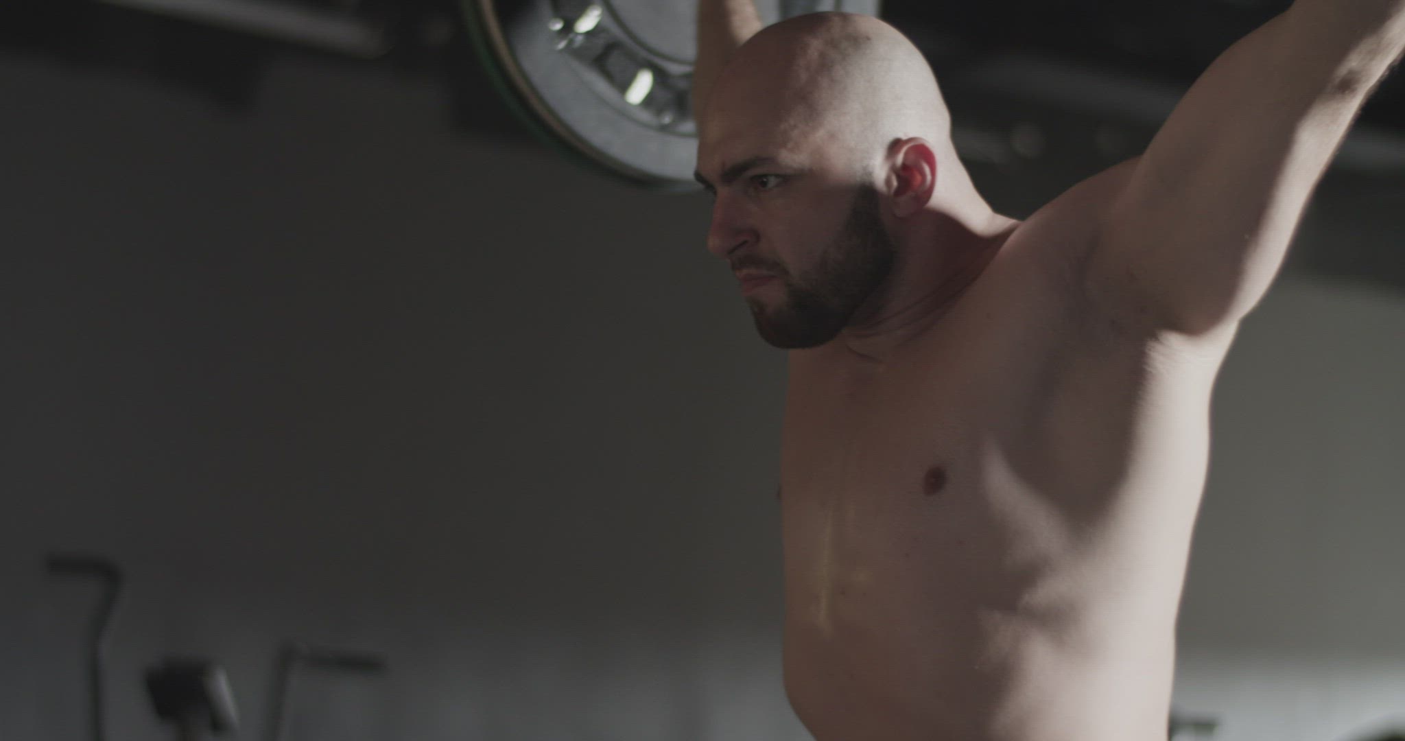 Concentrated sportsman doing squats with barbell