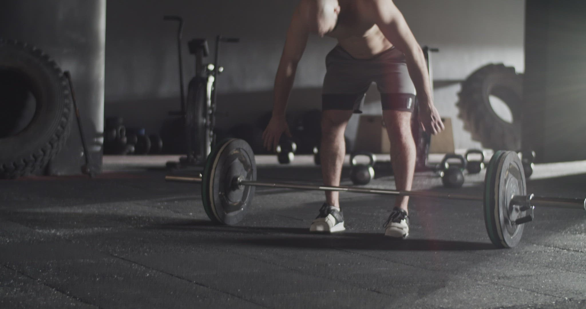 Muscular sportsman doing snatch exercise with barbell