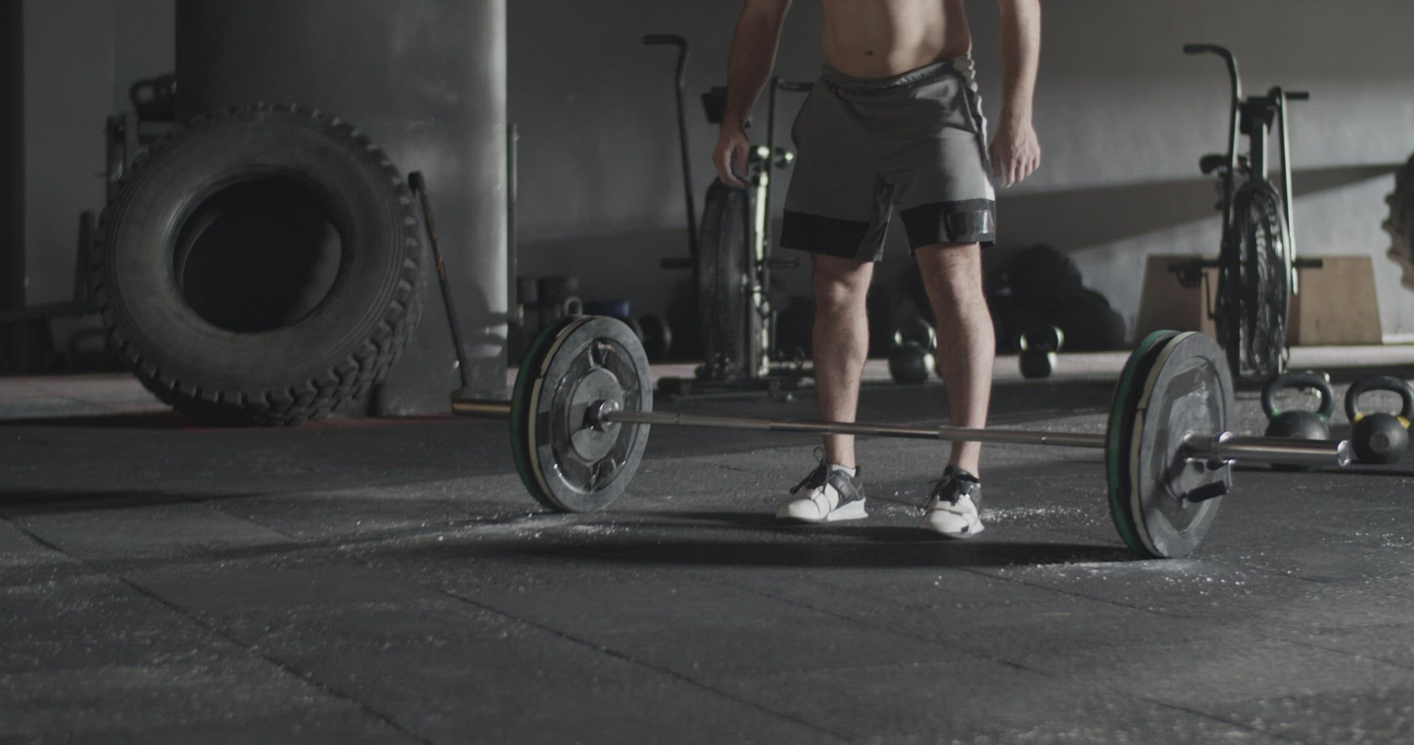 Athletic man doing clean and jerk exercise barbell in gym