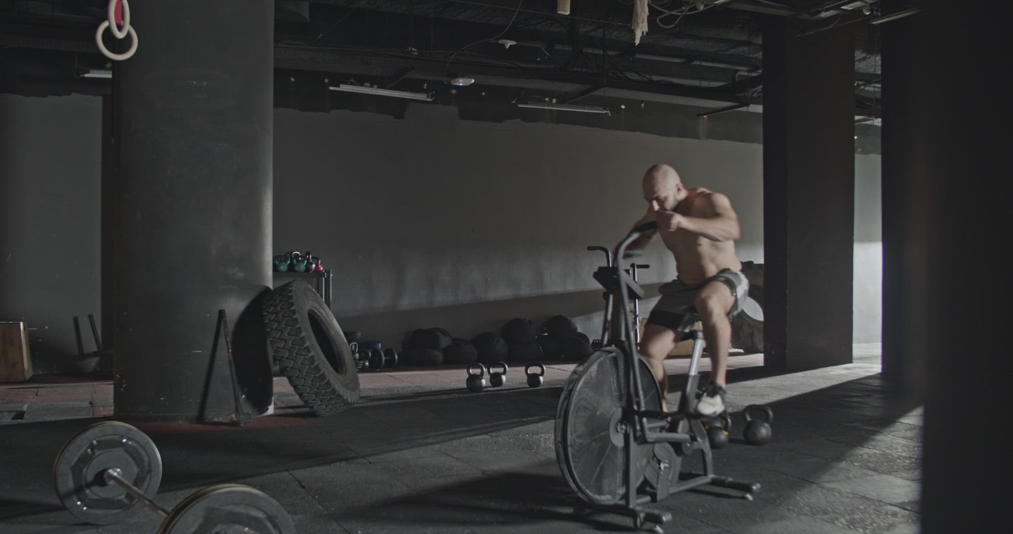 Active sportsman doing exercise on air bike