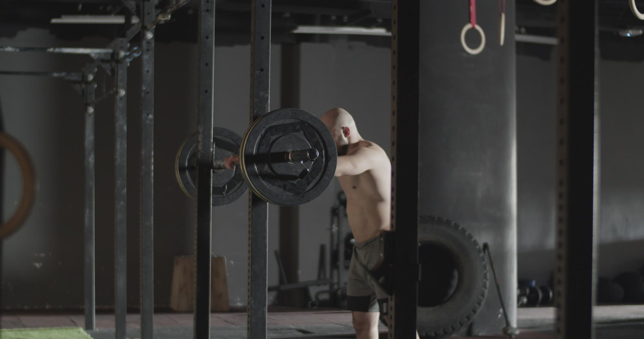 Strong sportsman doing squats with barbell