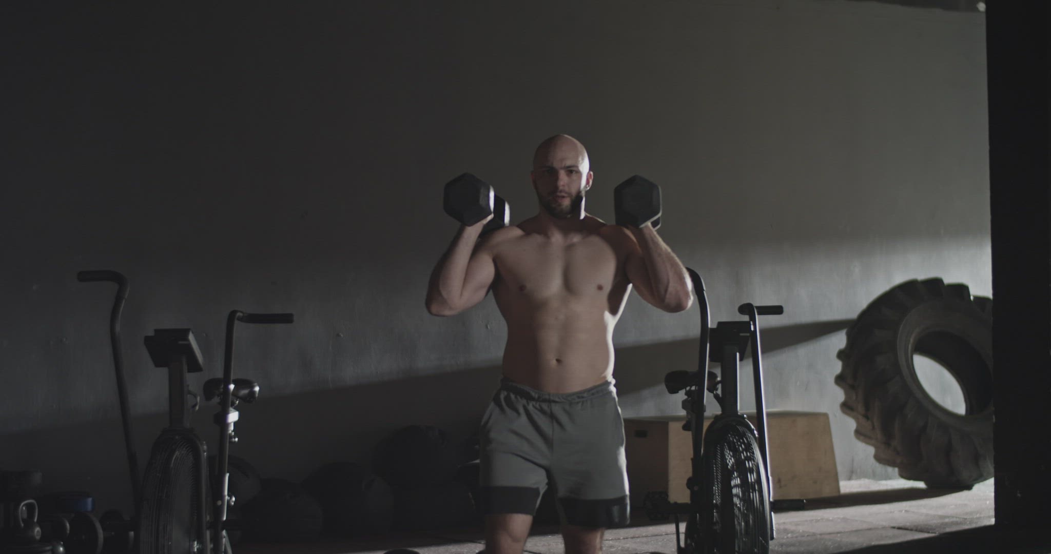 Strong sportsman doing lunges with dumbbells