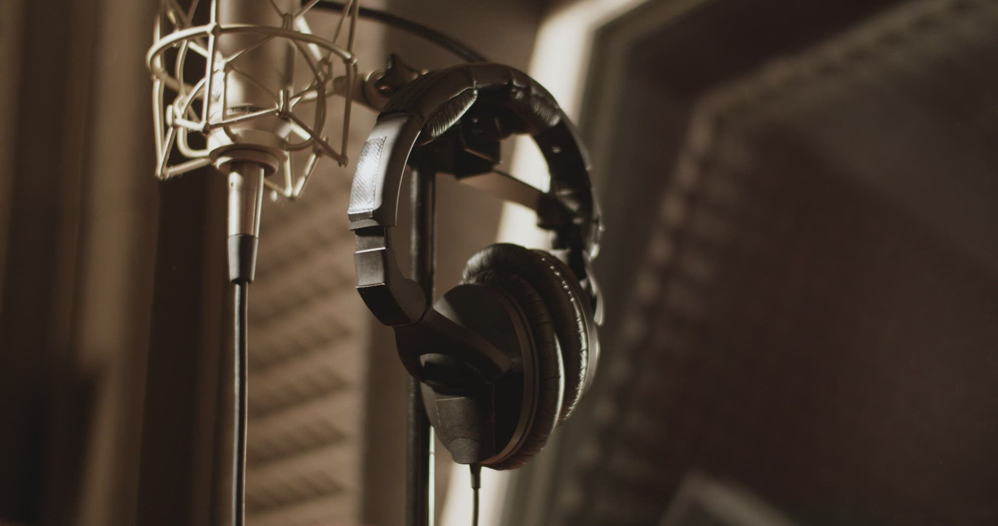 Cropped singer taking headphones in studio