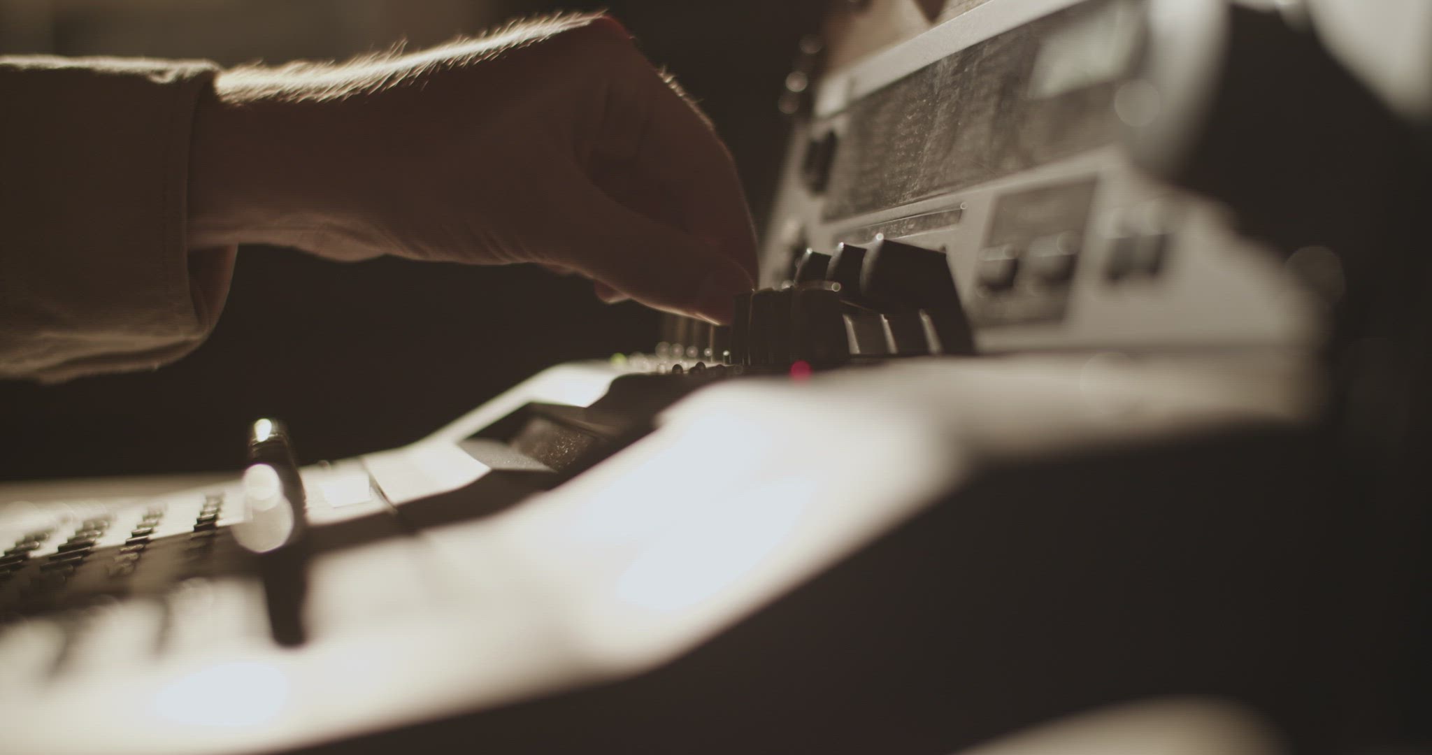 Producer turning knobs on soundboard