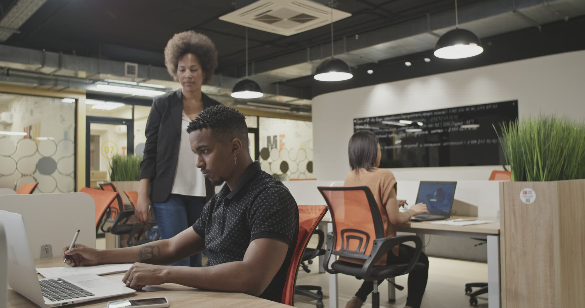 Black boss checking employee in office