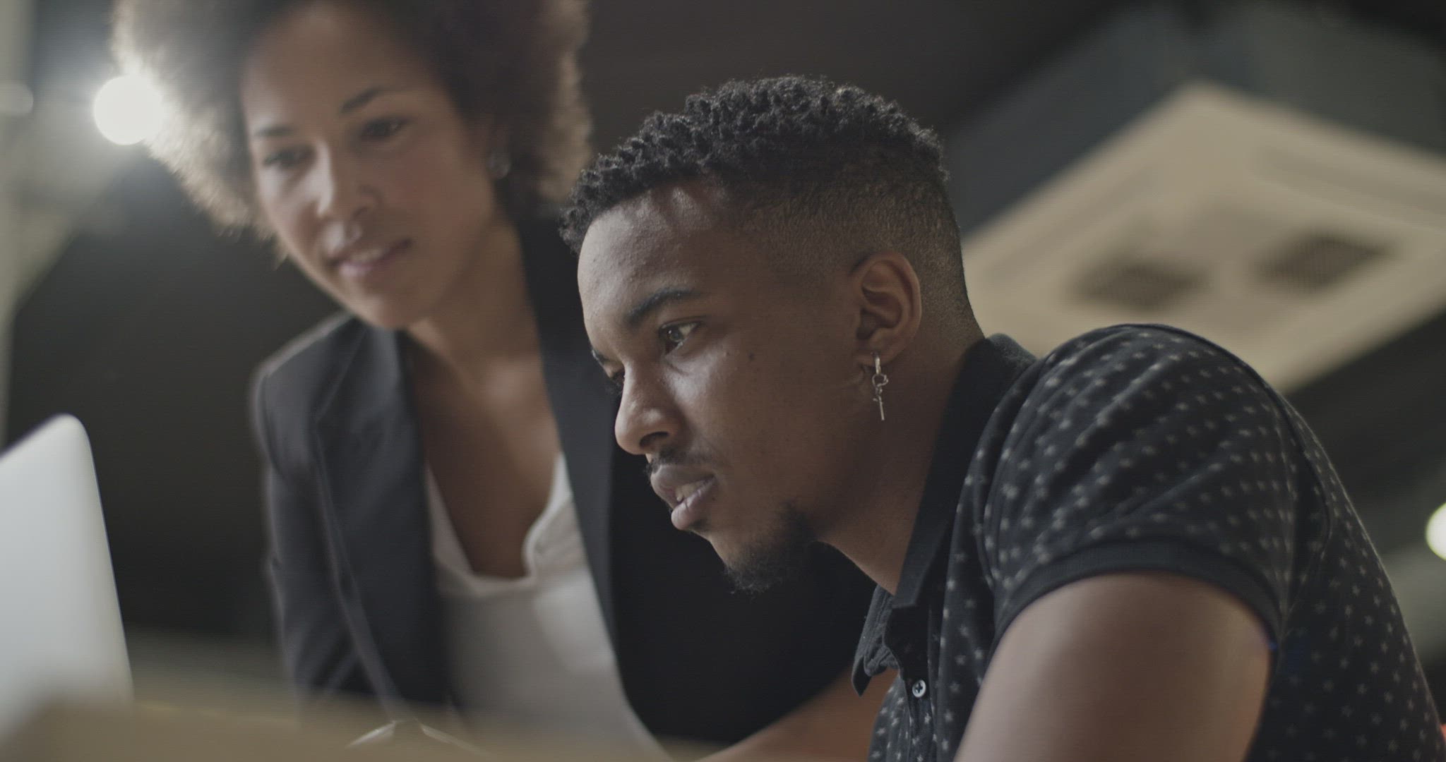 Black colleagues using laptop together