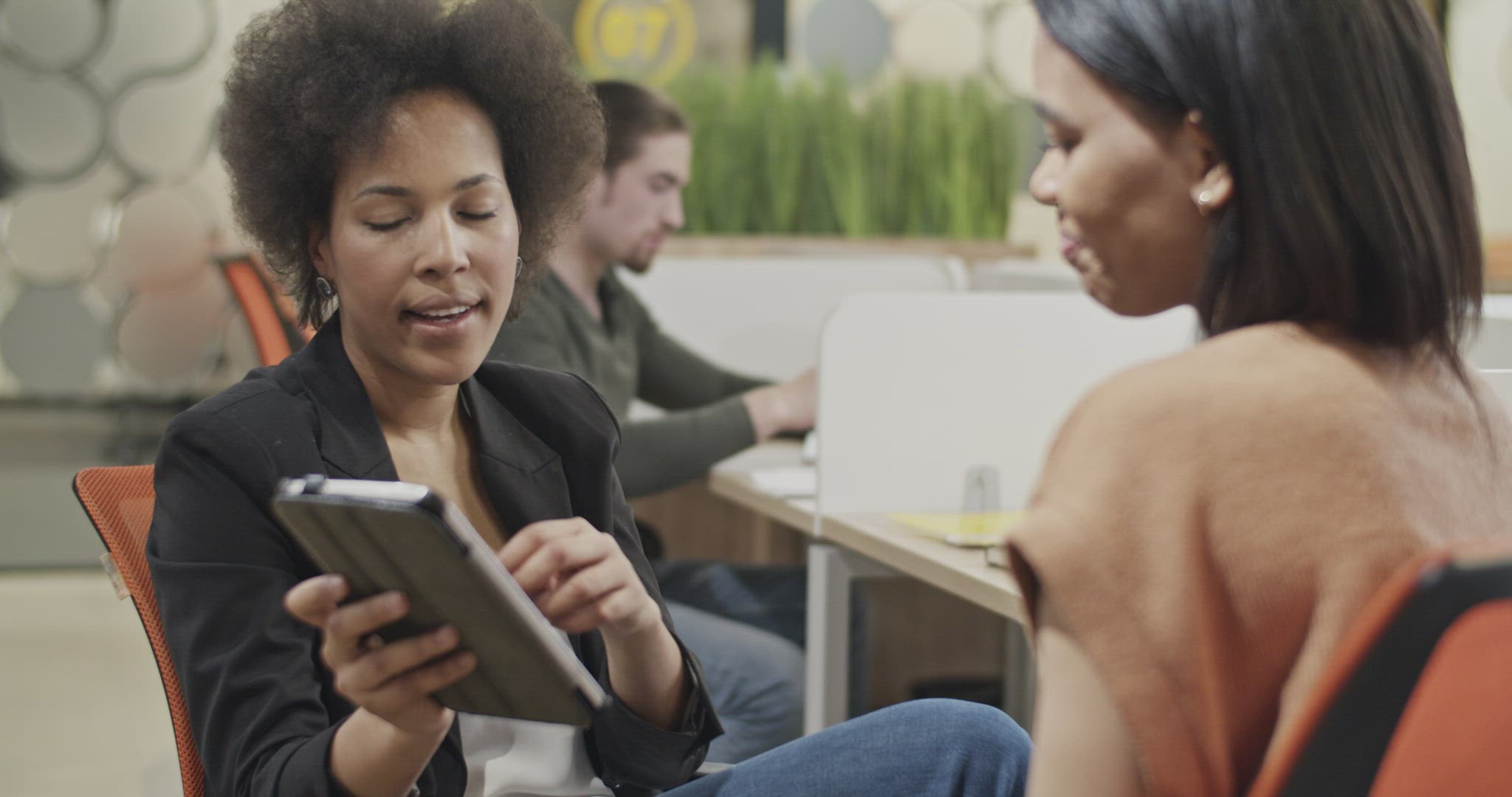 Businesswomen discussing data on tablet