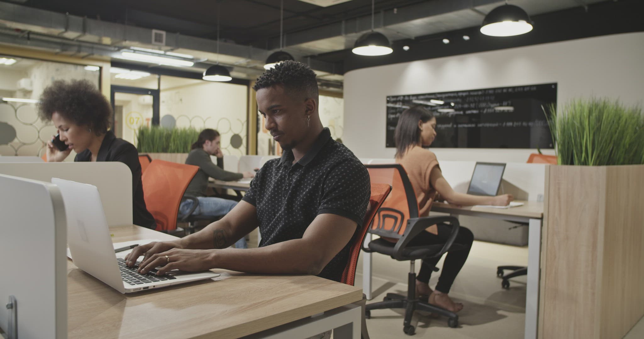 Diverse colleagues using laptops in office