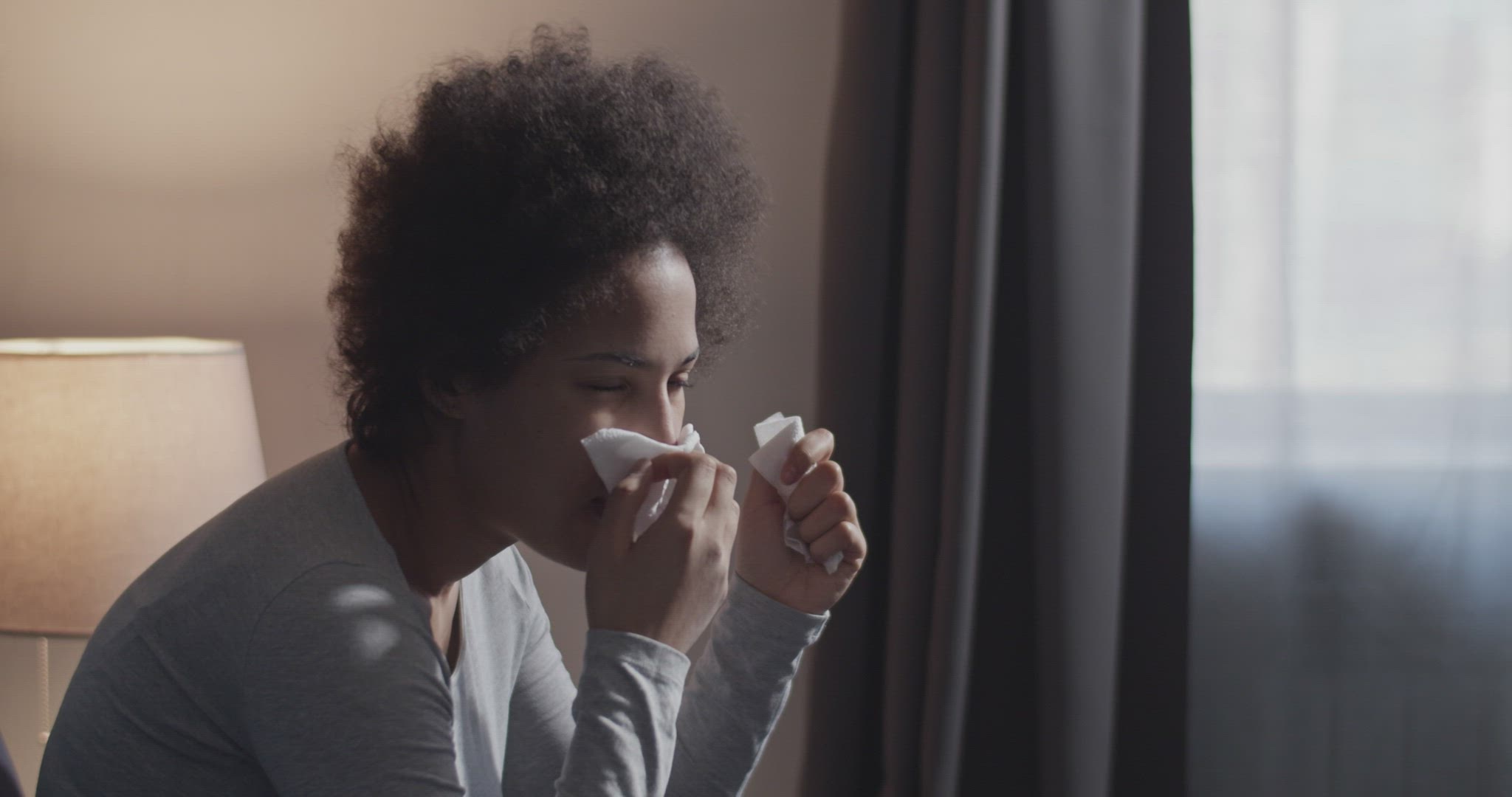 Sick black woman blowing nose