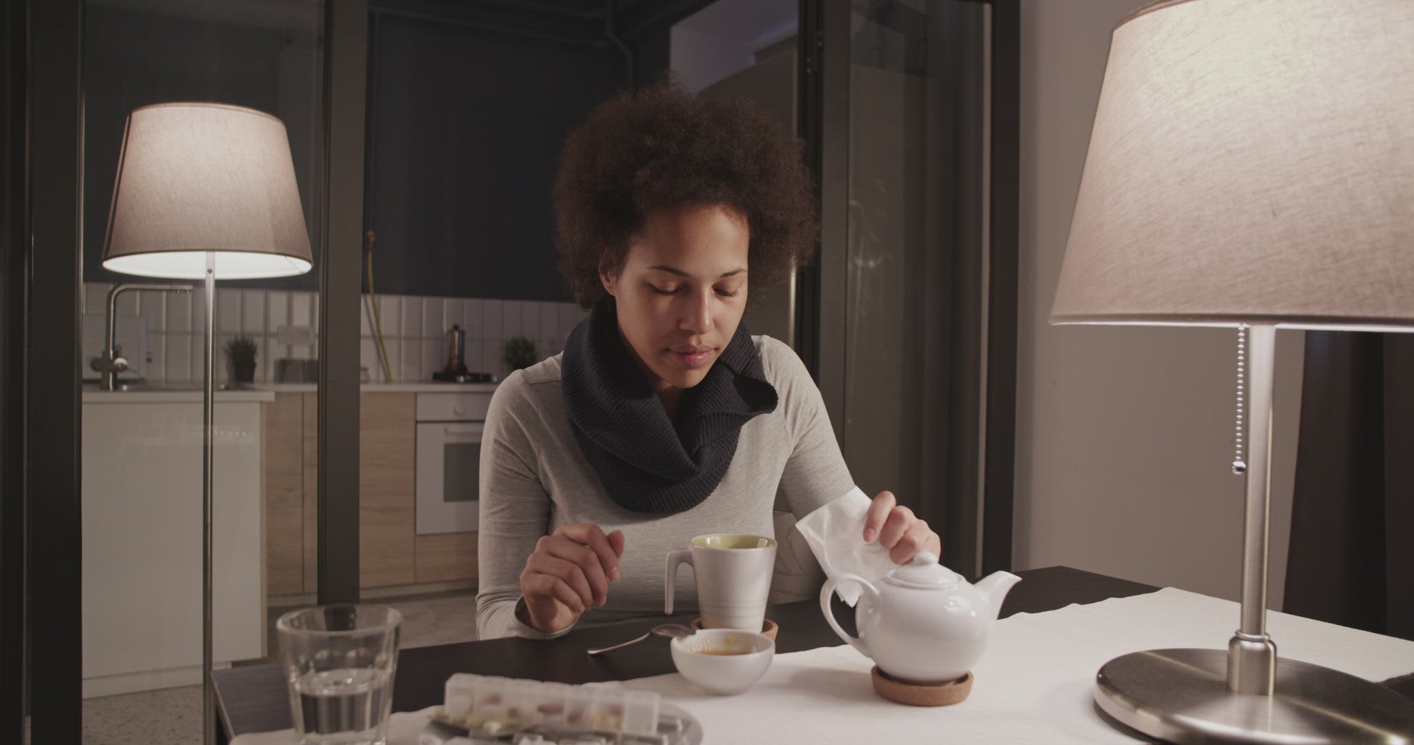 Black female blowing nose and drinking tea