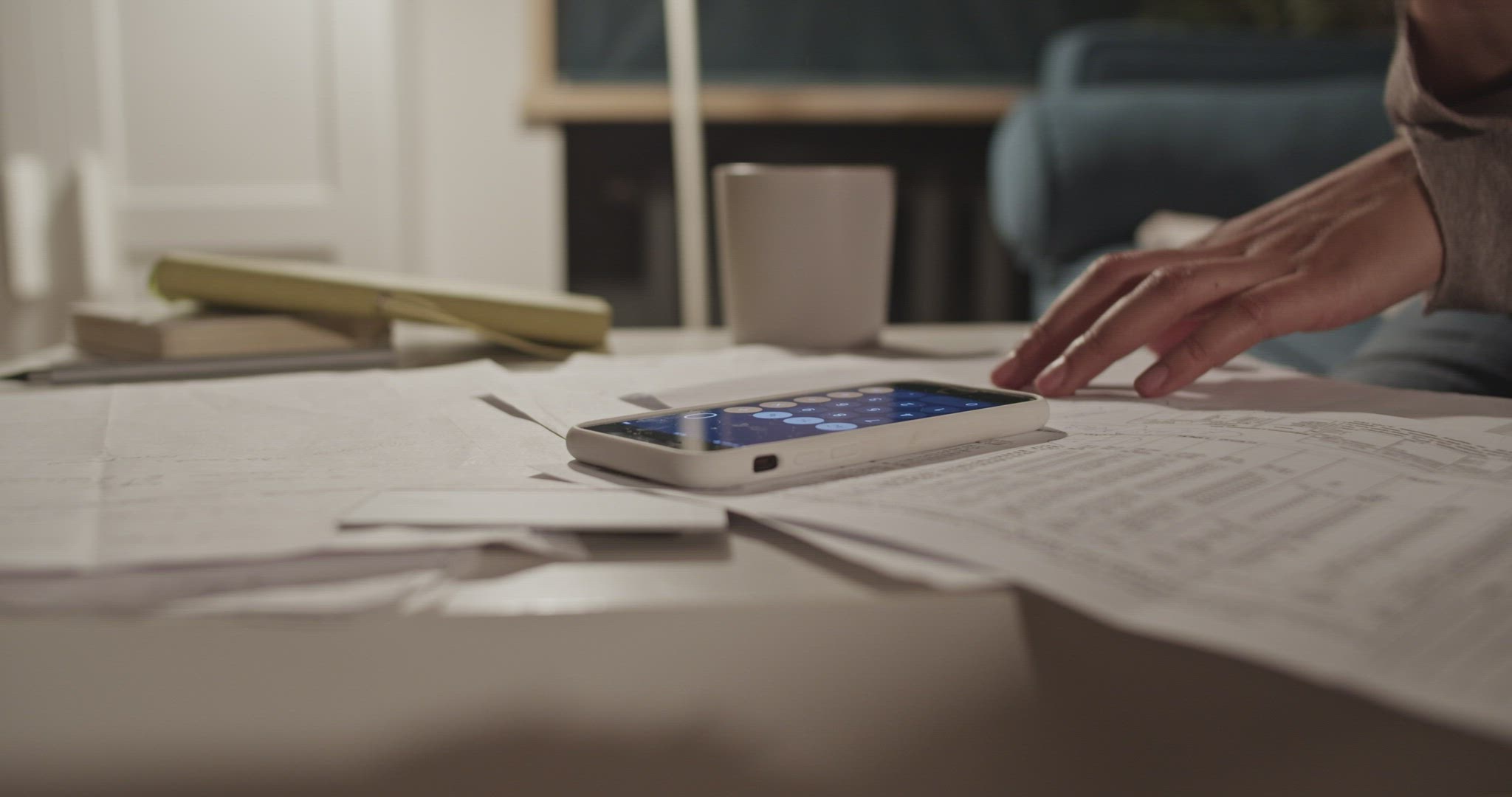 Black woman using calculator app and making notes while paying bills