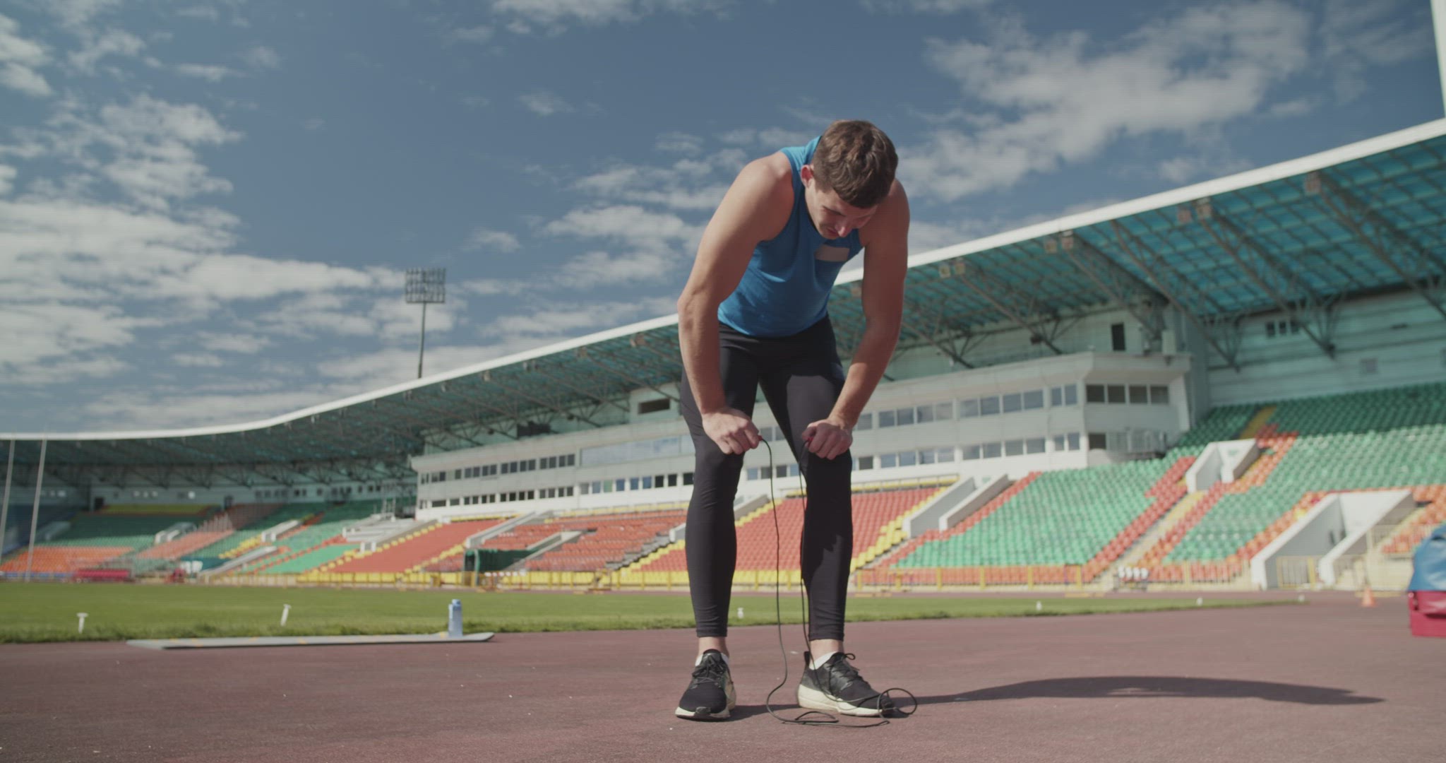 Sportsman with jumping rope taking break