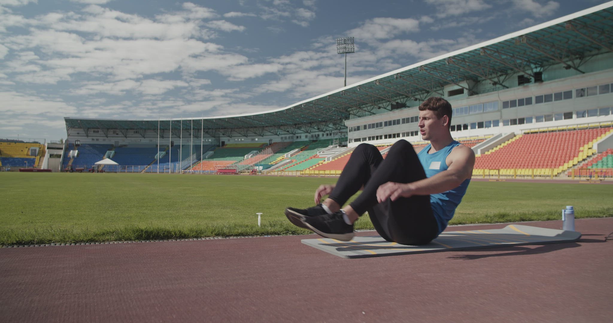 Sportsman doing abs exercise on stadium