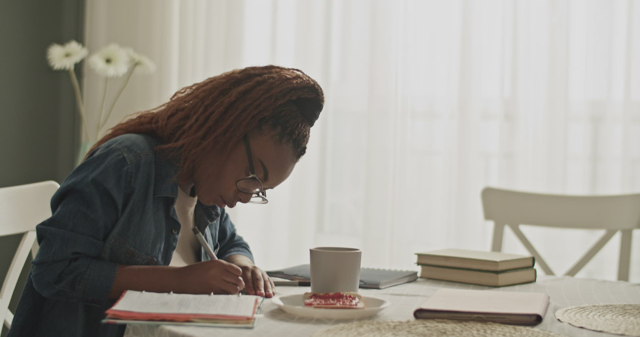 Black student making notes near food