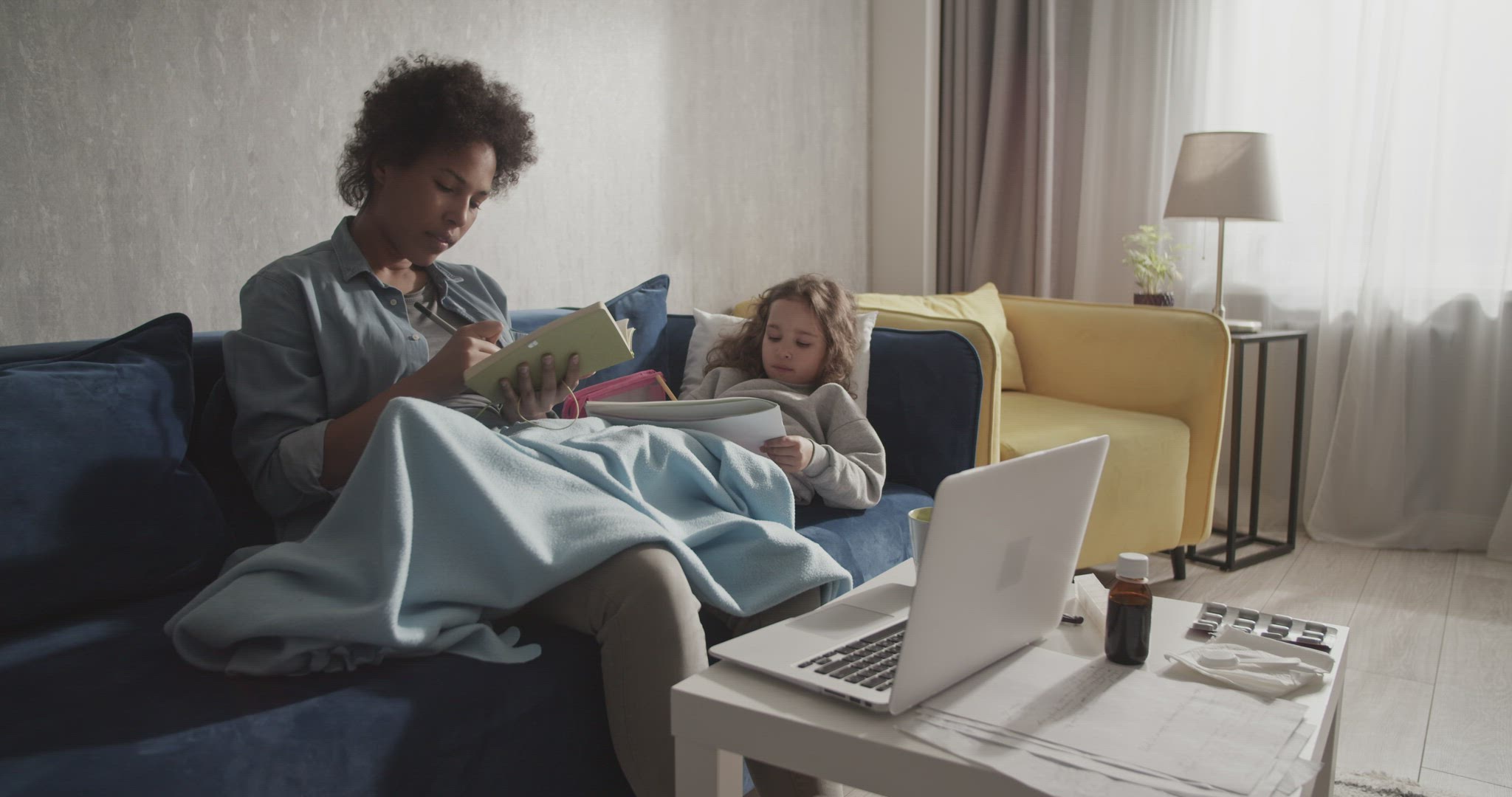 Black mom finishing remote work near sick kid