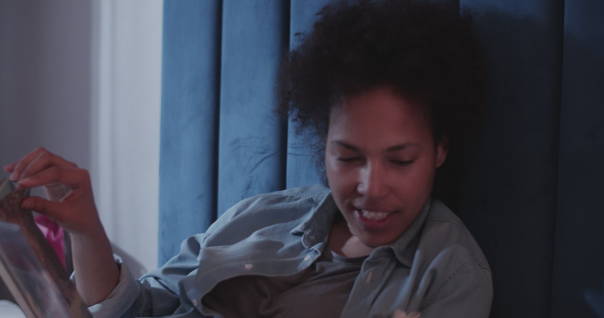 Black mom reading book to kid at night