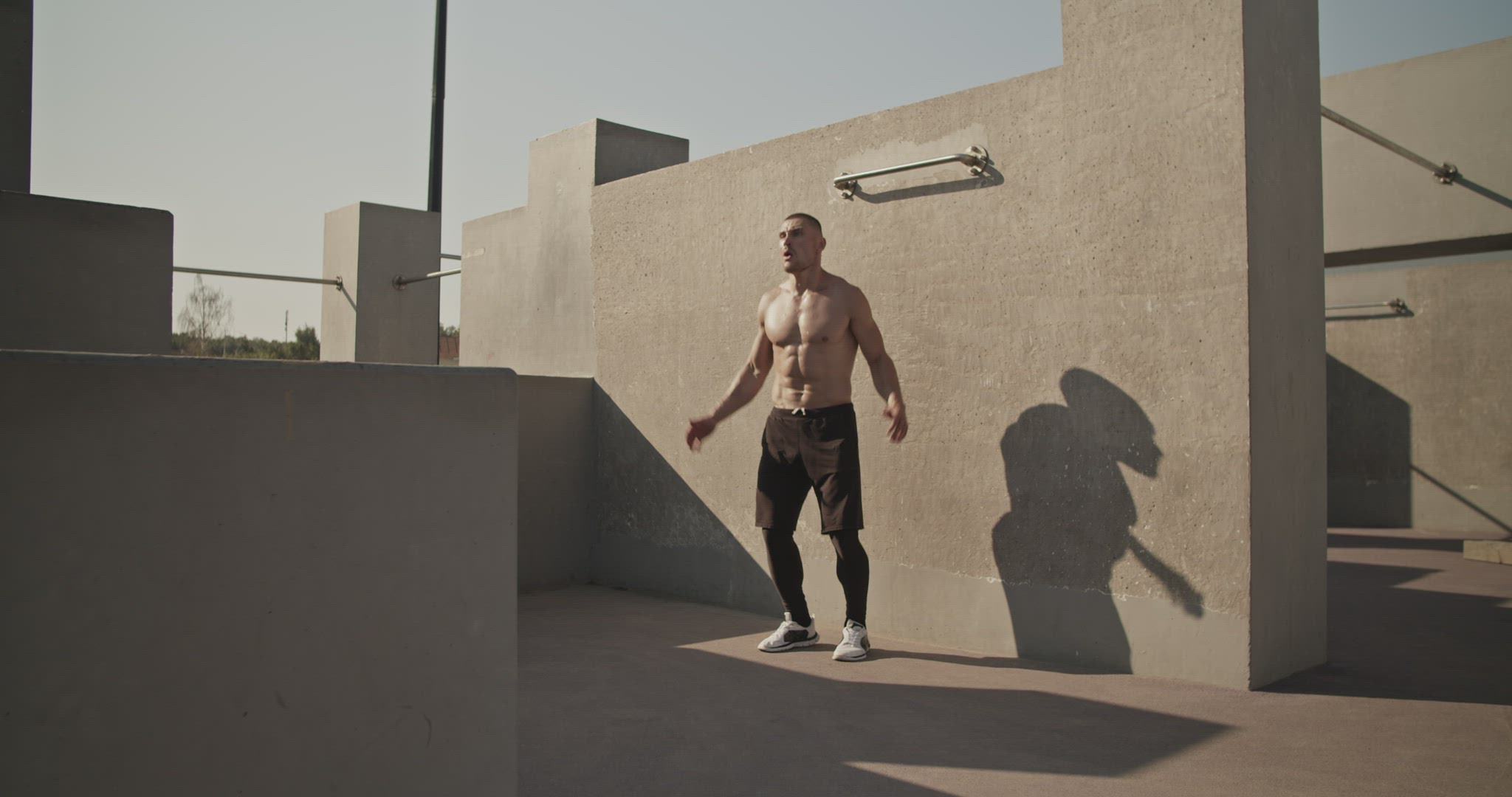 Sportsman doing jumping jacks on sports ground