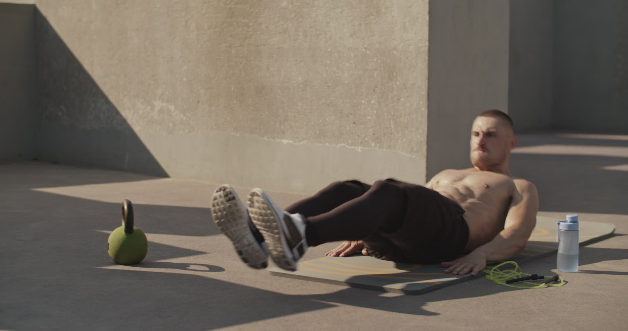 Sportsman doing abs exercise on sports ground