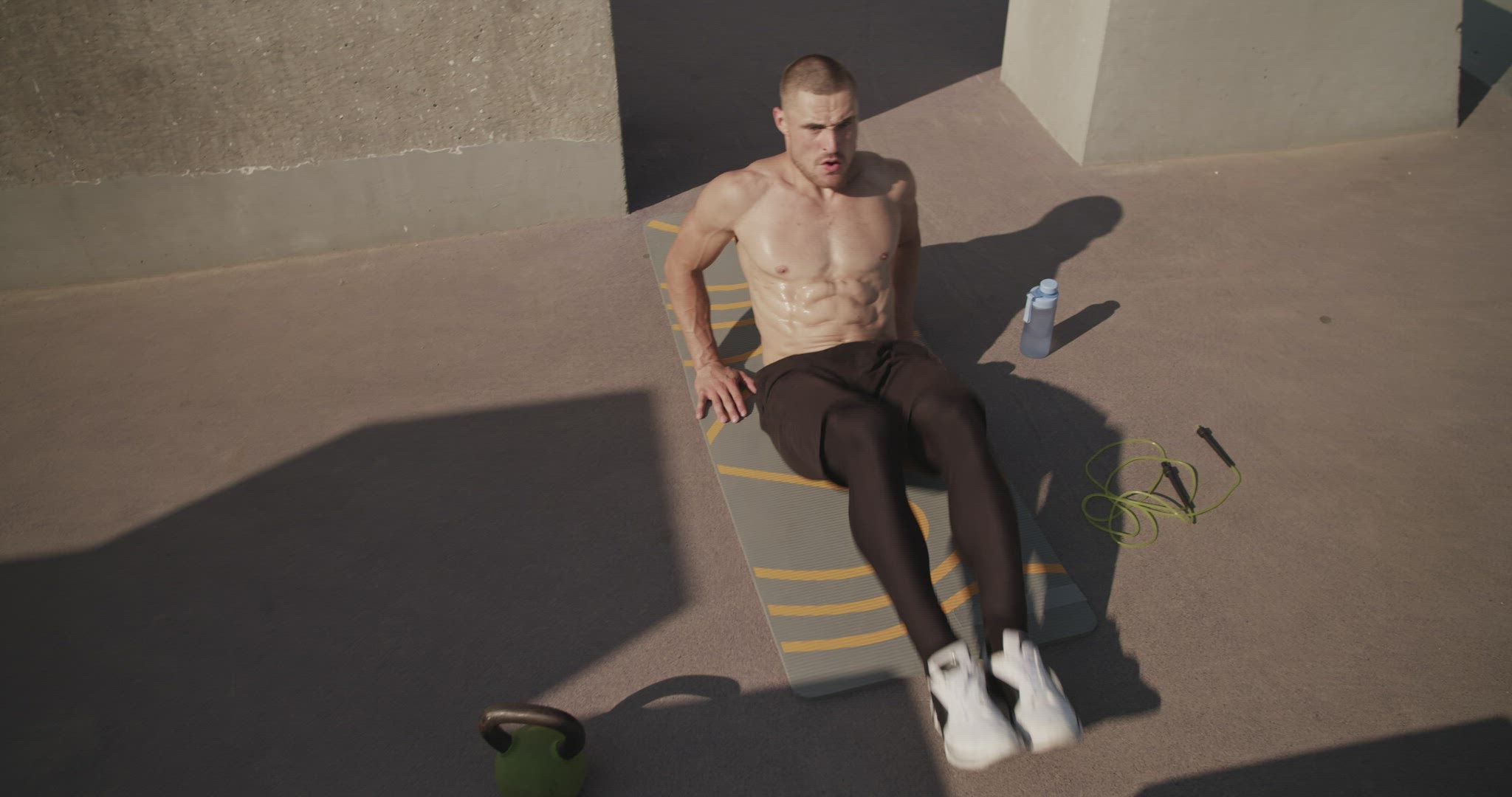 Sportsman exercising near water and jumping rope