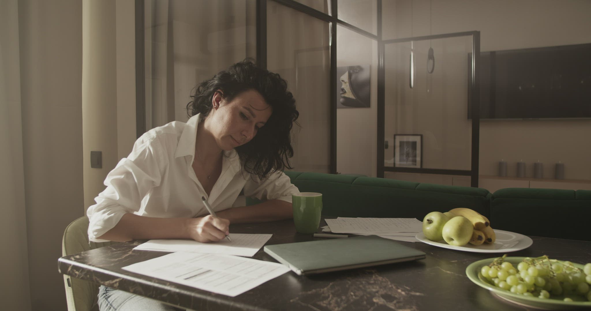 Businesswoman drinking coffee and making notes