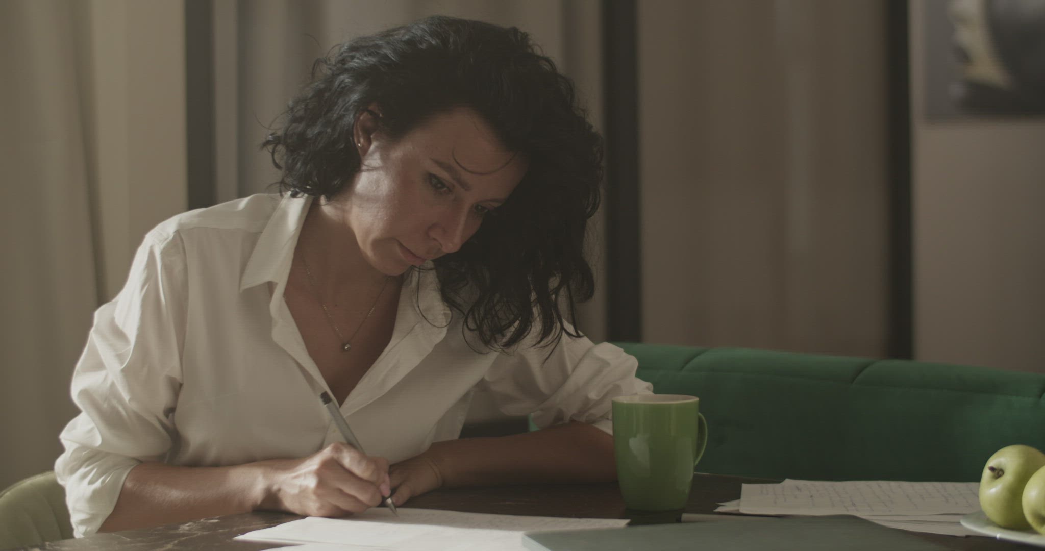 Businesswoman drinking coffee and making notes