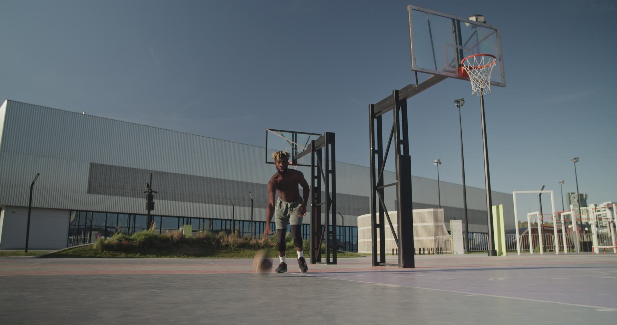 African American sportsman dribbling ball on court