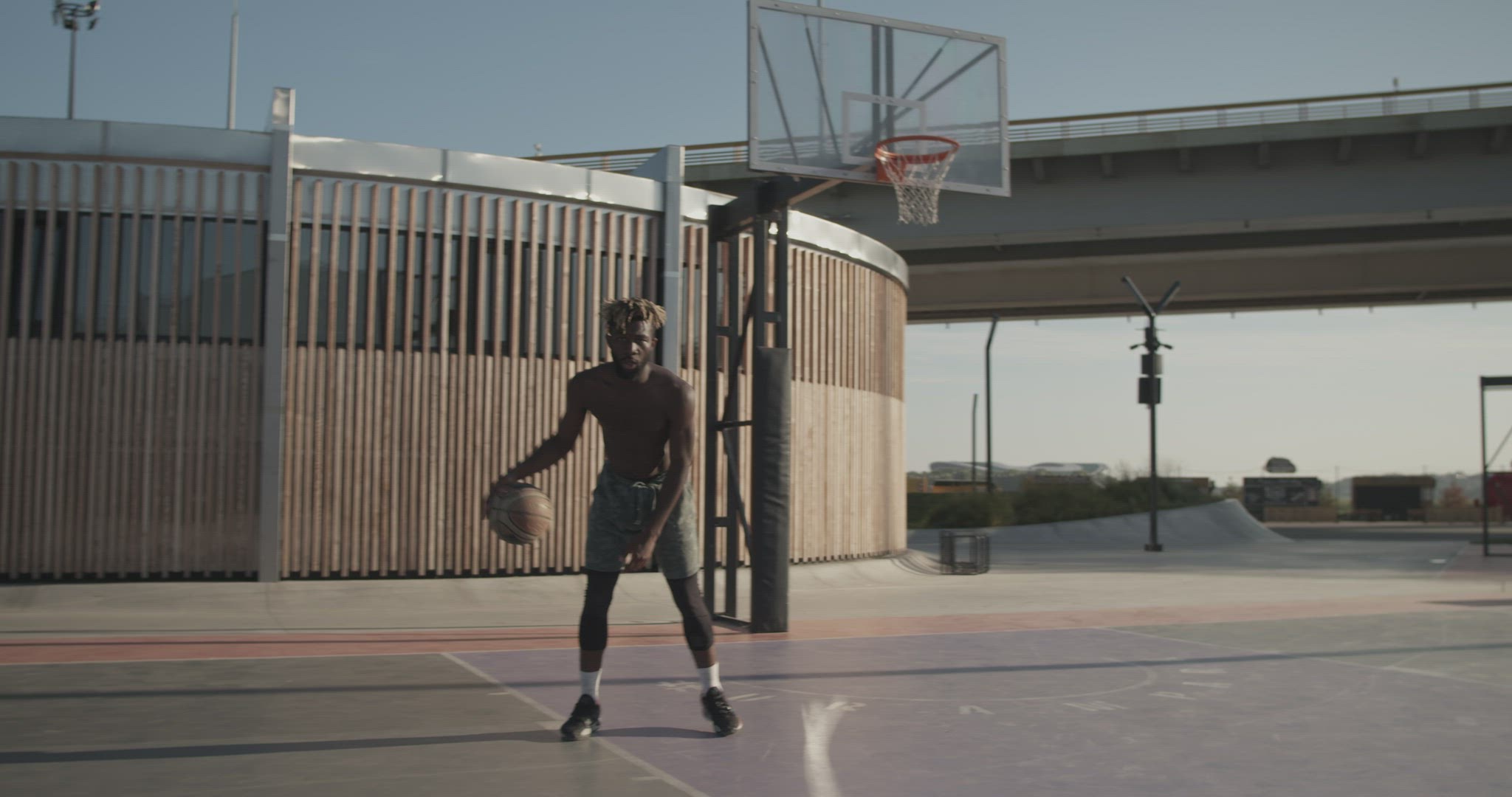 Black streetball player doing freestyle tricks and running to hoop