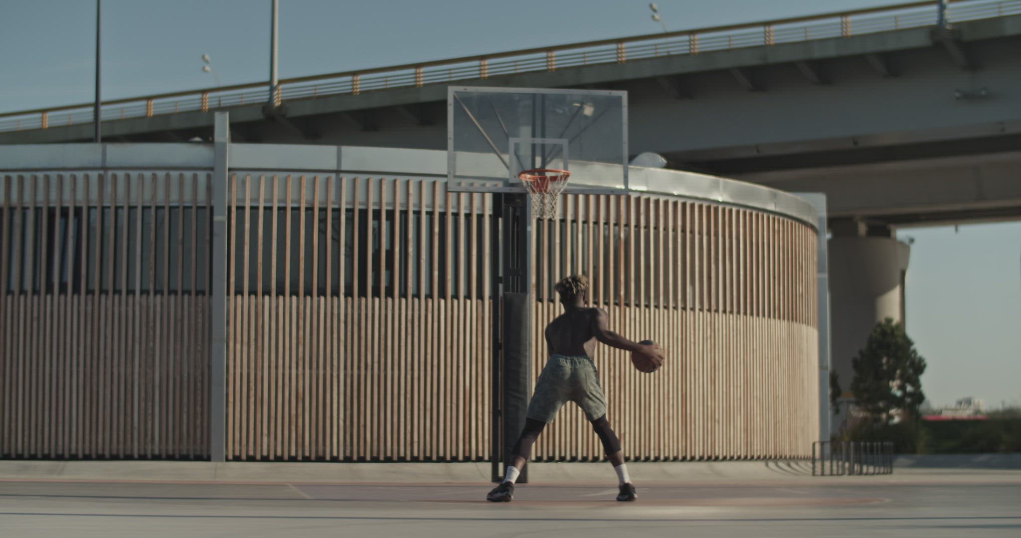 Basketball player practicing dribbling near ring