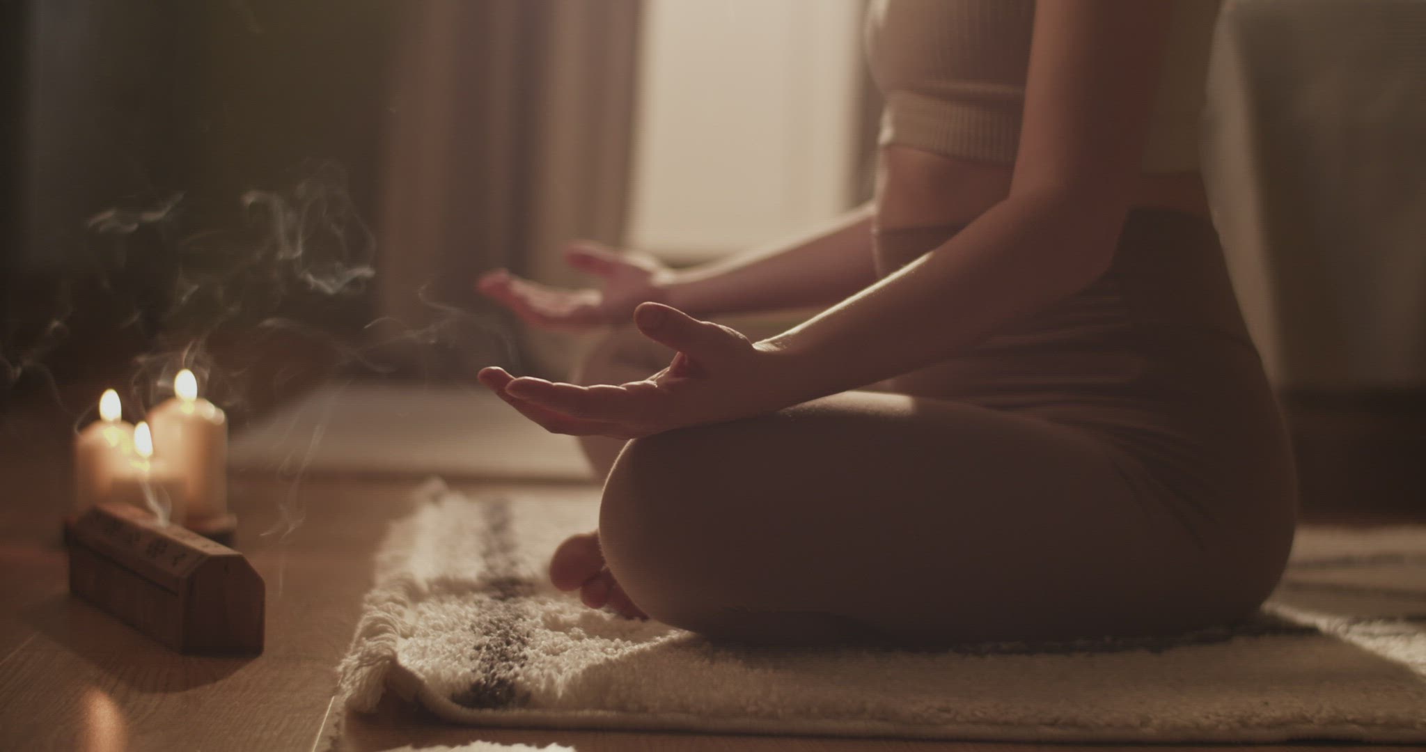 Female meditating near tea and incense