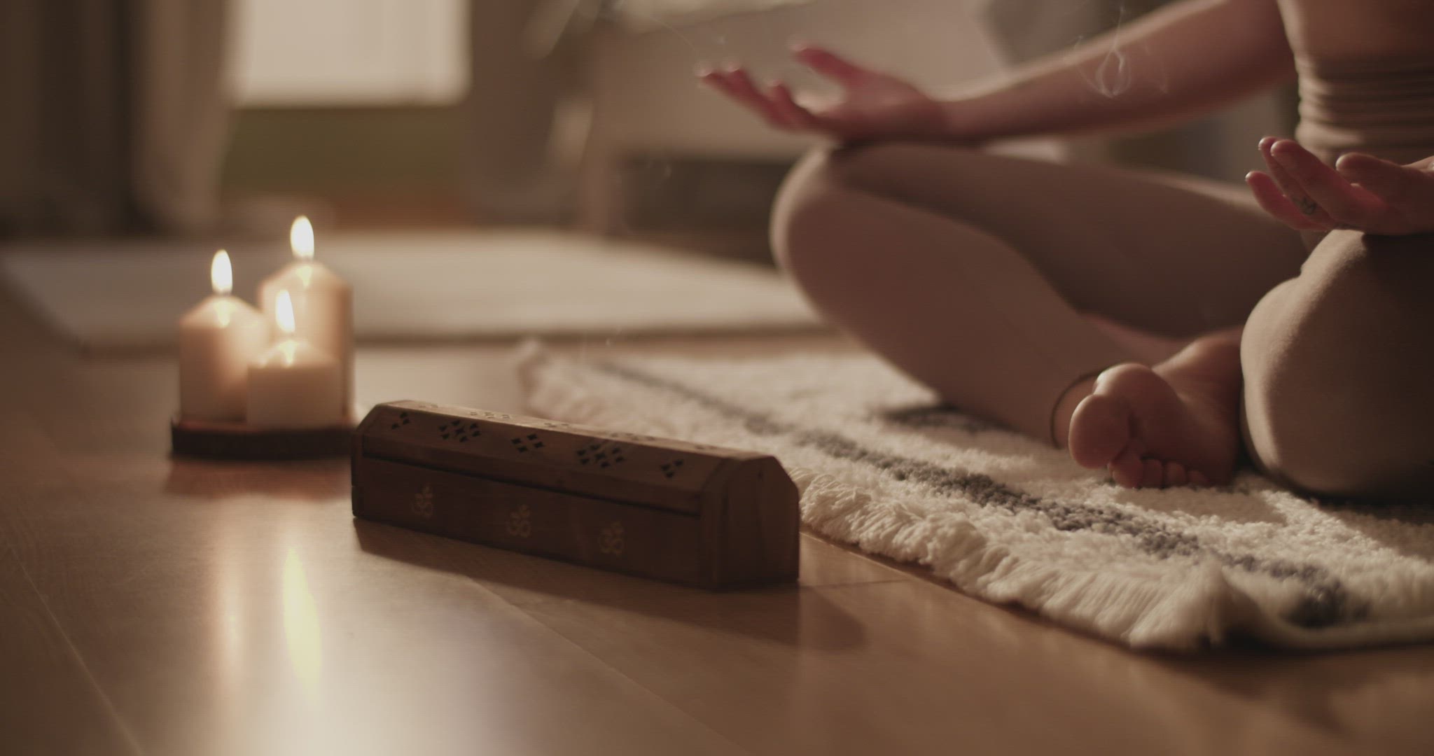 Female meditating near aromatic candles