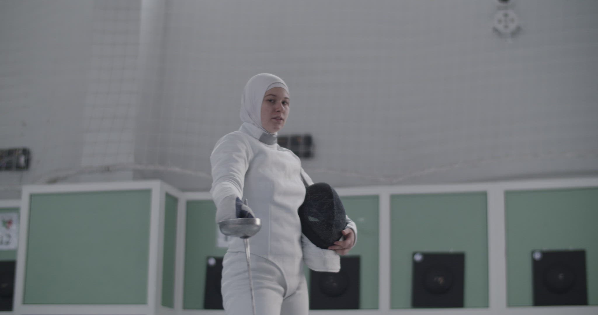 Sweaty Muslim sportswoman in fencing gym