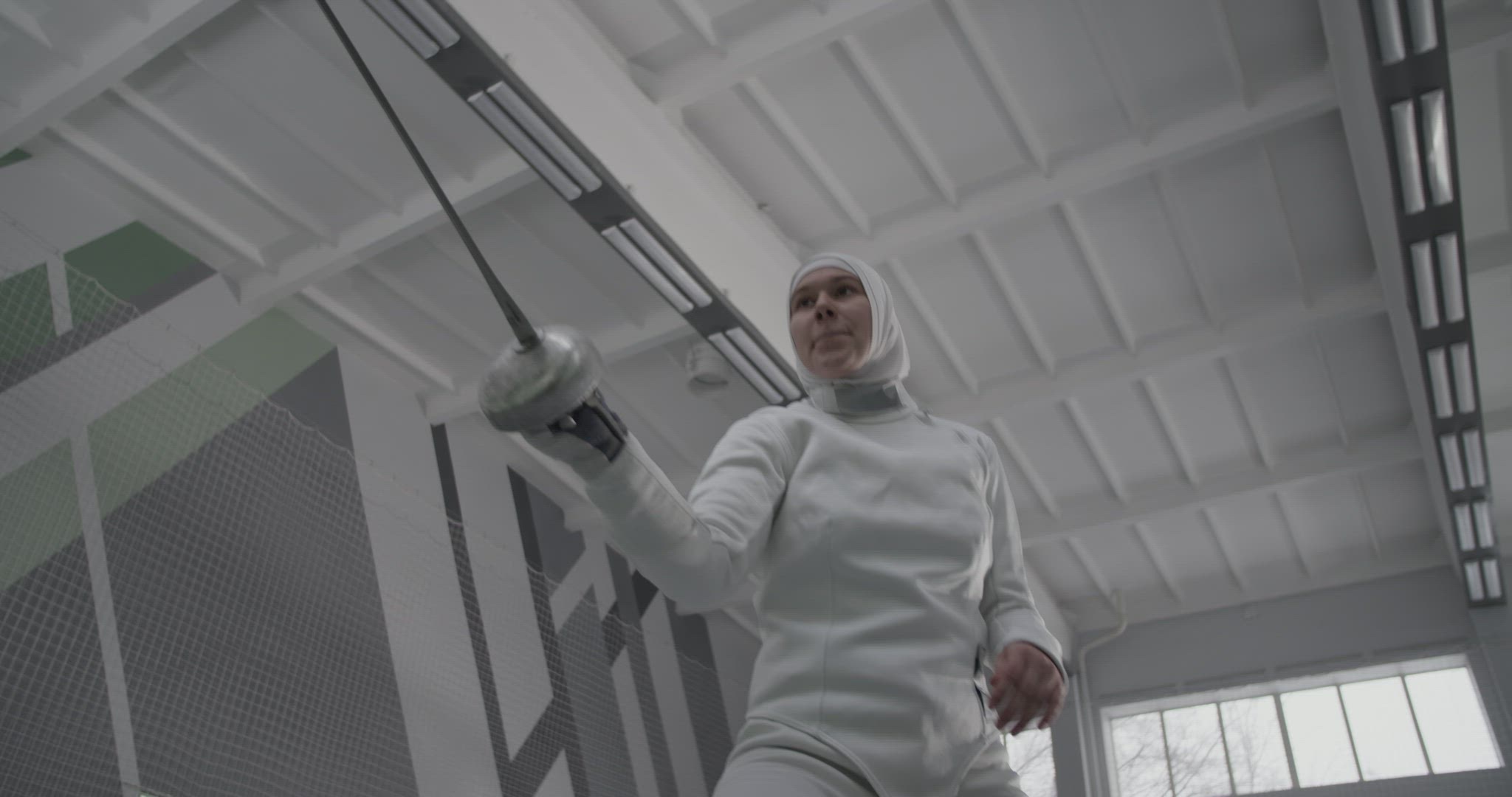 Muslim fencer hitting air with foil