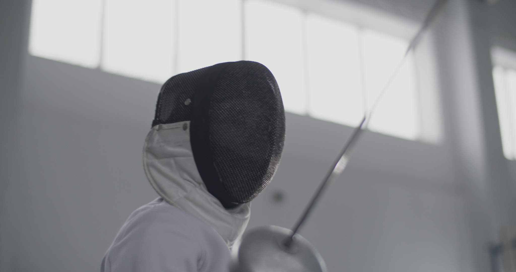 Female fencer training with opponent