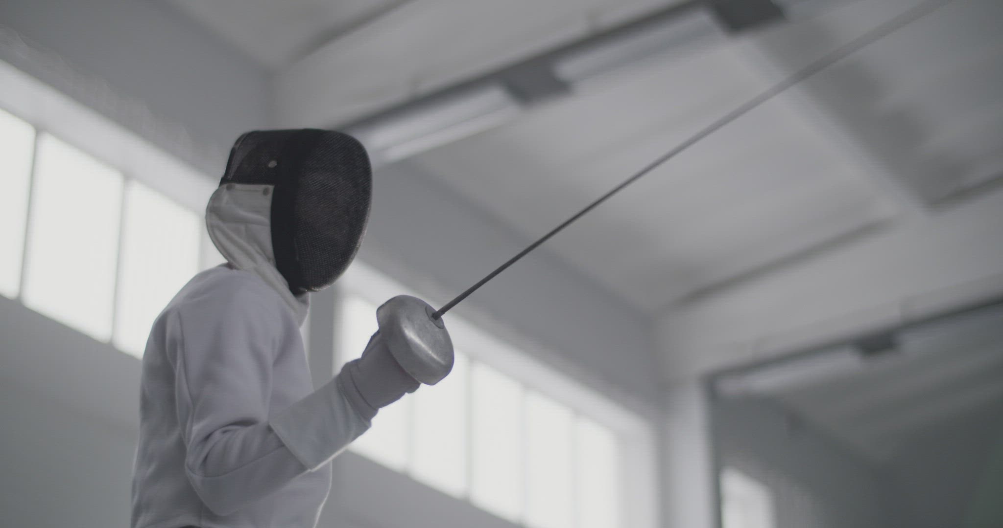 Female fencer training with opponent