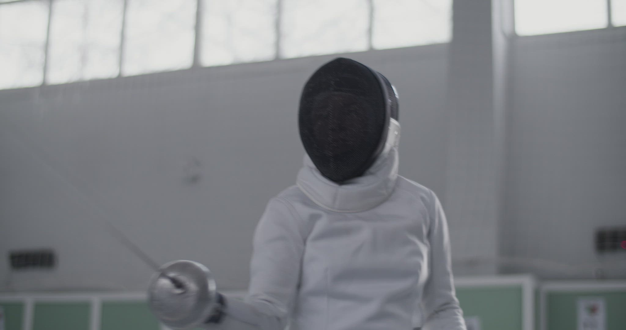 Female fencer training with opponent