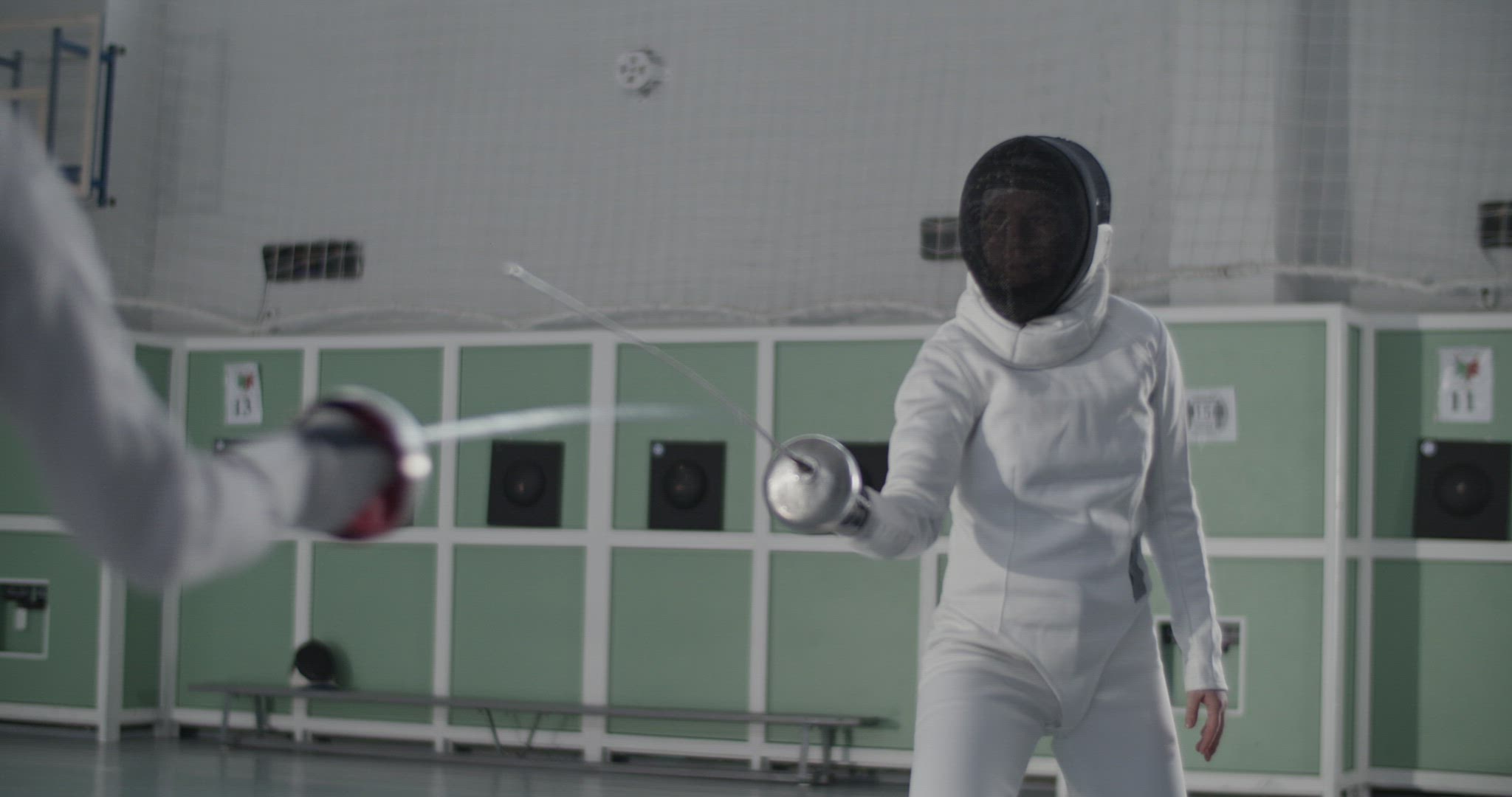 Female fencer evading attack of opponent