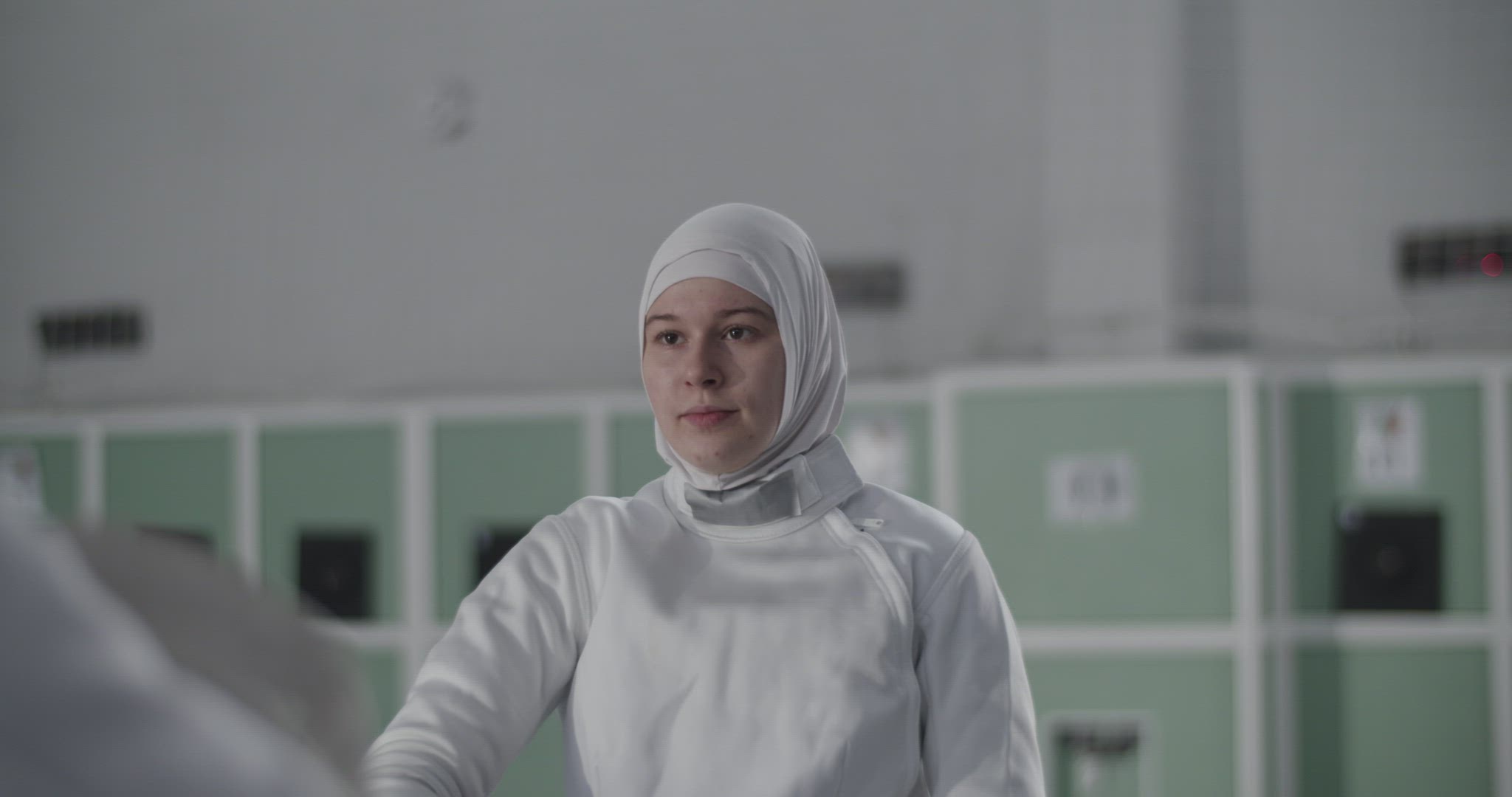 Muslim fencer putting on helmet